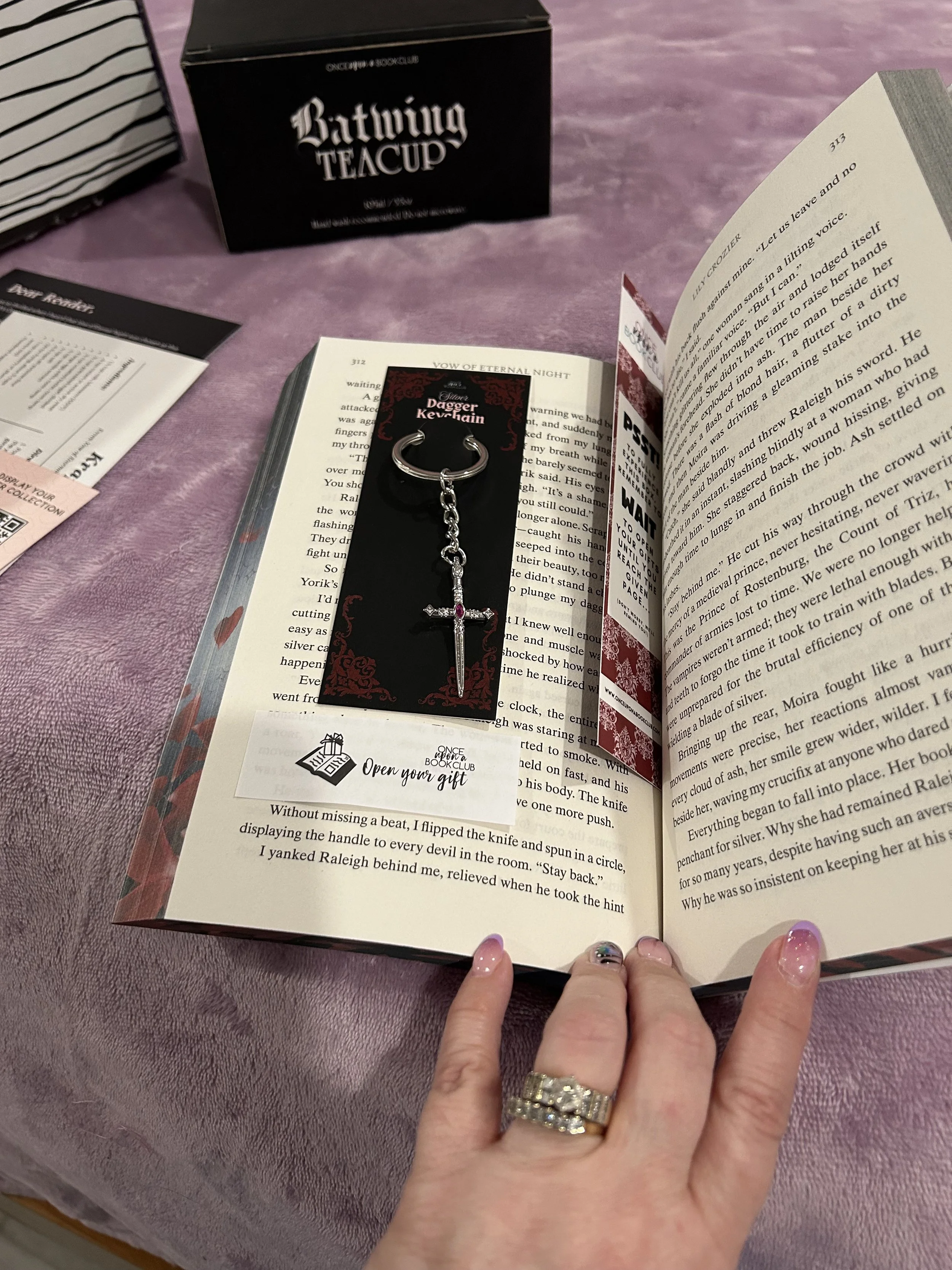 Silver dagger keychain with a red stone displayed over Vow of Eternal Night.