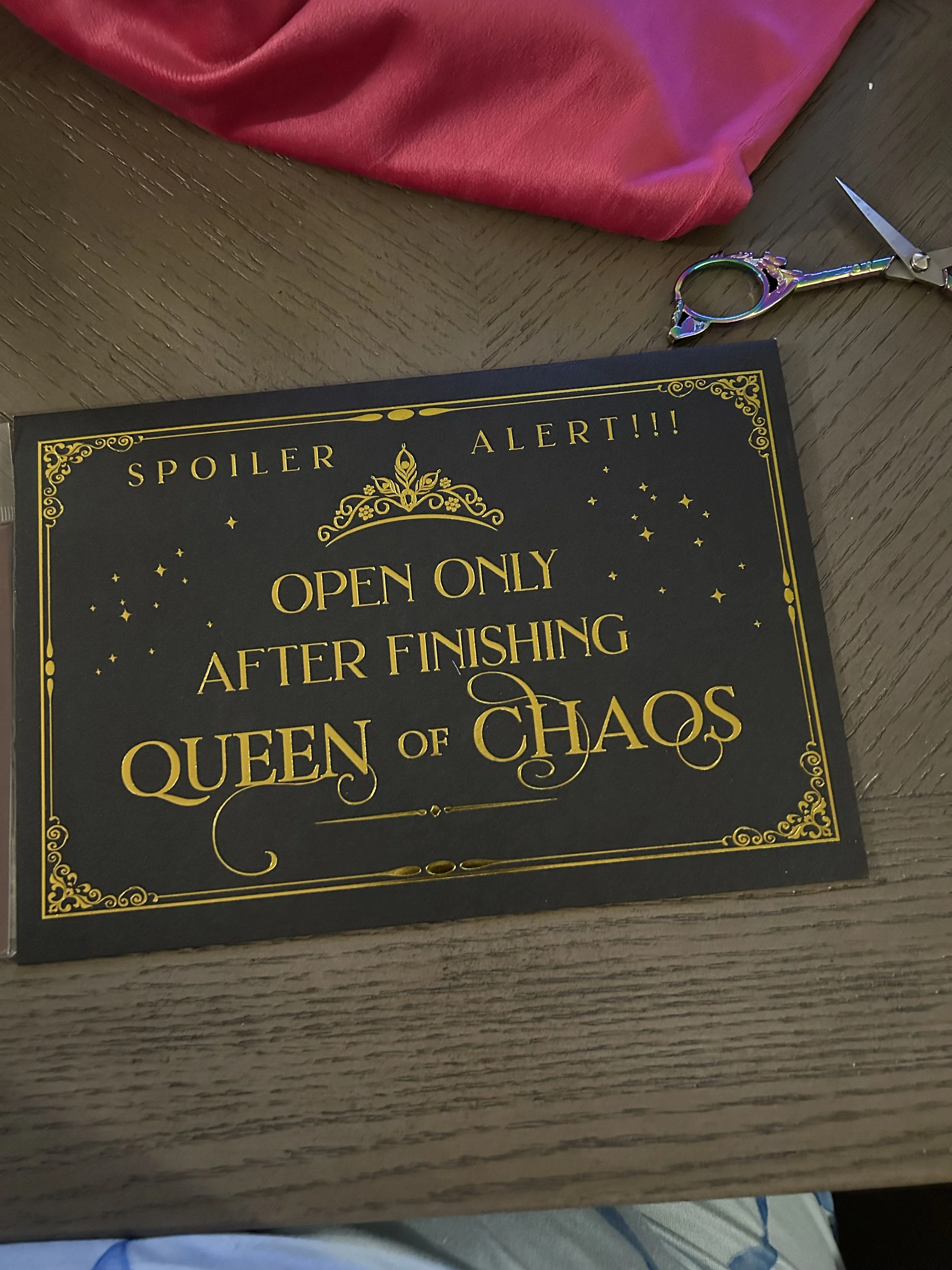 Black Queen of Chaos spoiler envelope with ornate gold borders and instructions to open only after finishing the book.