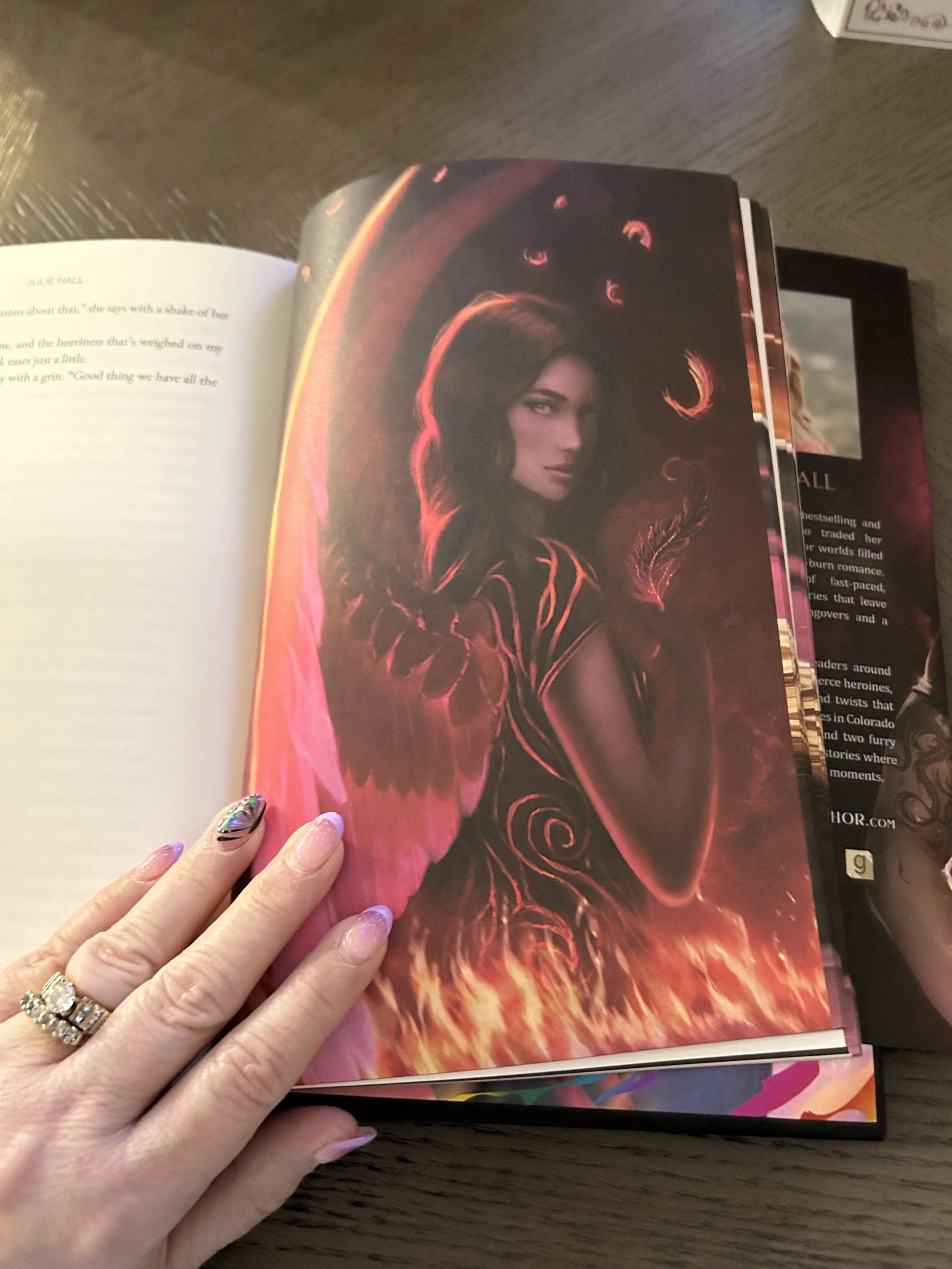 Full-page Queen of Chaos fantasy illustration of a dark-haired winged woman with flames along the bottom.