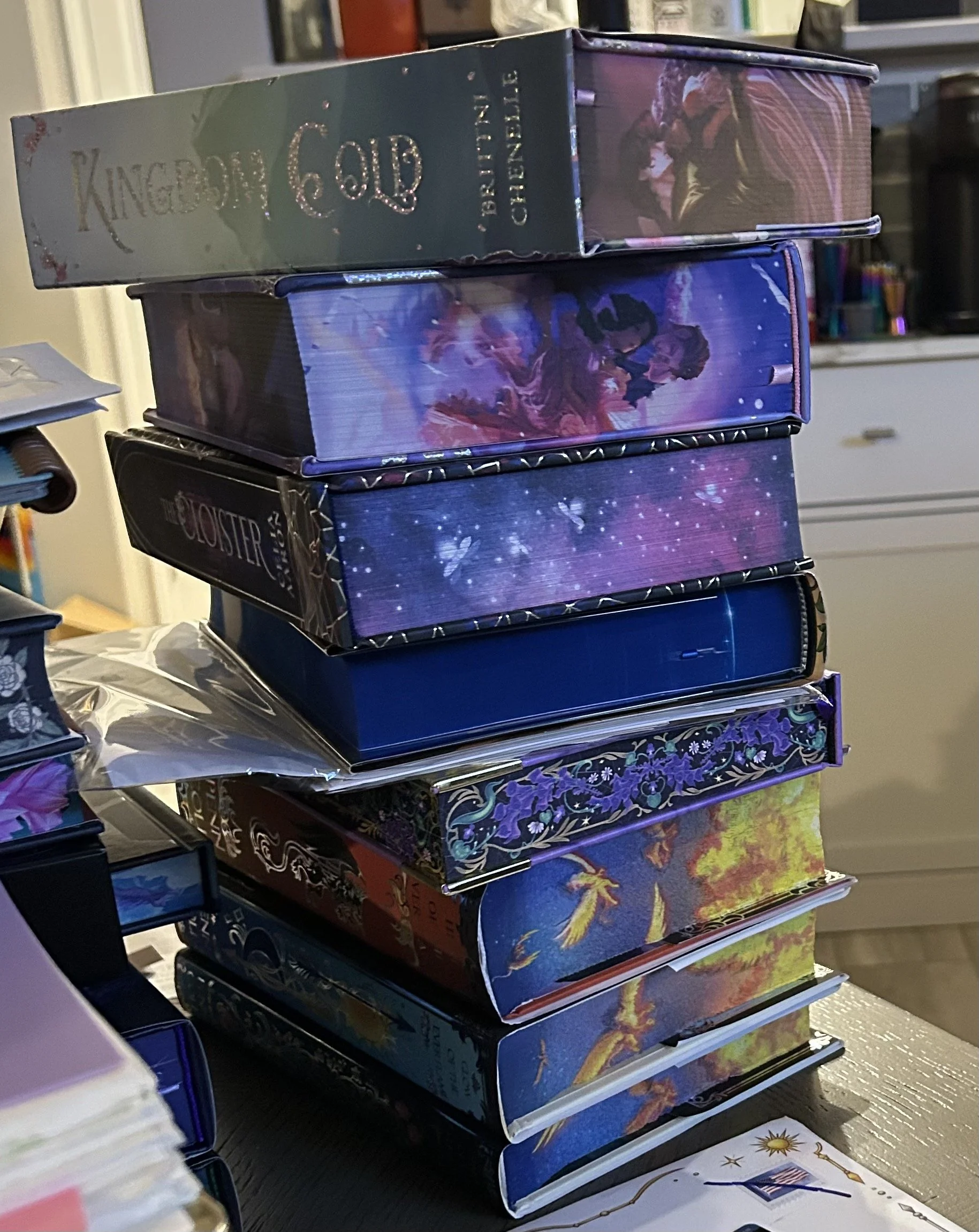 Stack of colorful special-edition books with decorative sprayed edges.