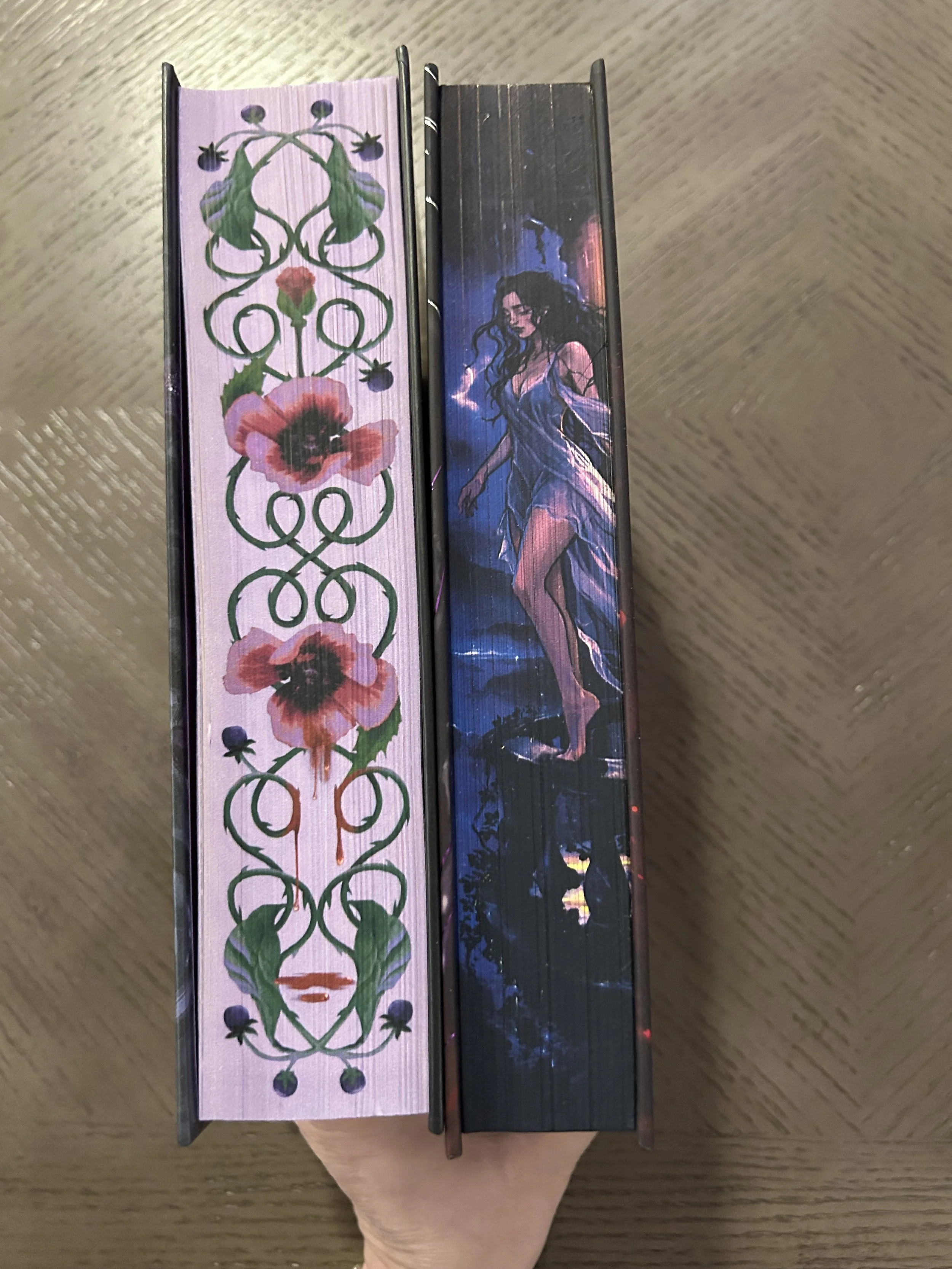 The illustrated page edges of two editions of The Poison Daughter side by side: lavender poisonous flowers and curling vines on the retail hardcover, and a woman in a blue dress against a dark scene on the Coveted Cover edition.