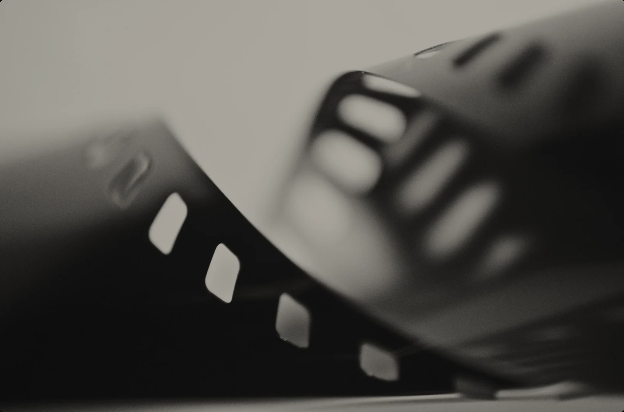 Close-up of a metal object with a series of slotted vents or openings, possibly part of electronic or mechanical equipment, with a monochrome color scheme.