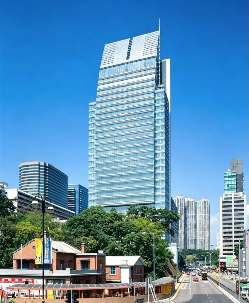 People exiting Hong Kong MTR station entrance, surrounded by tall city buildings in an urban setting.