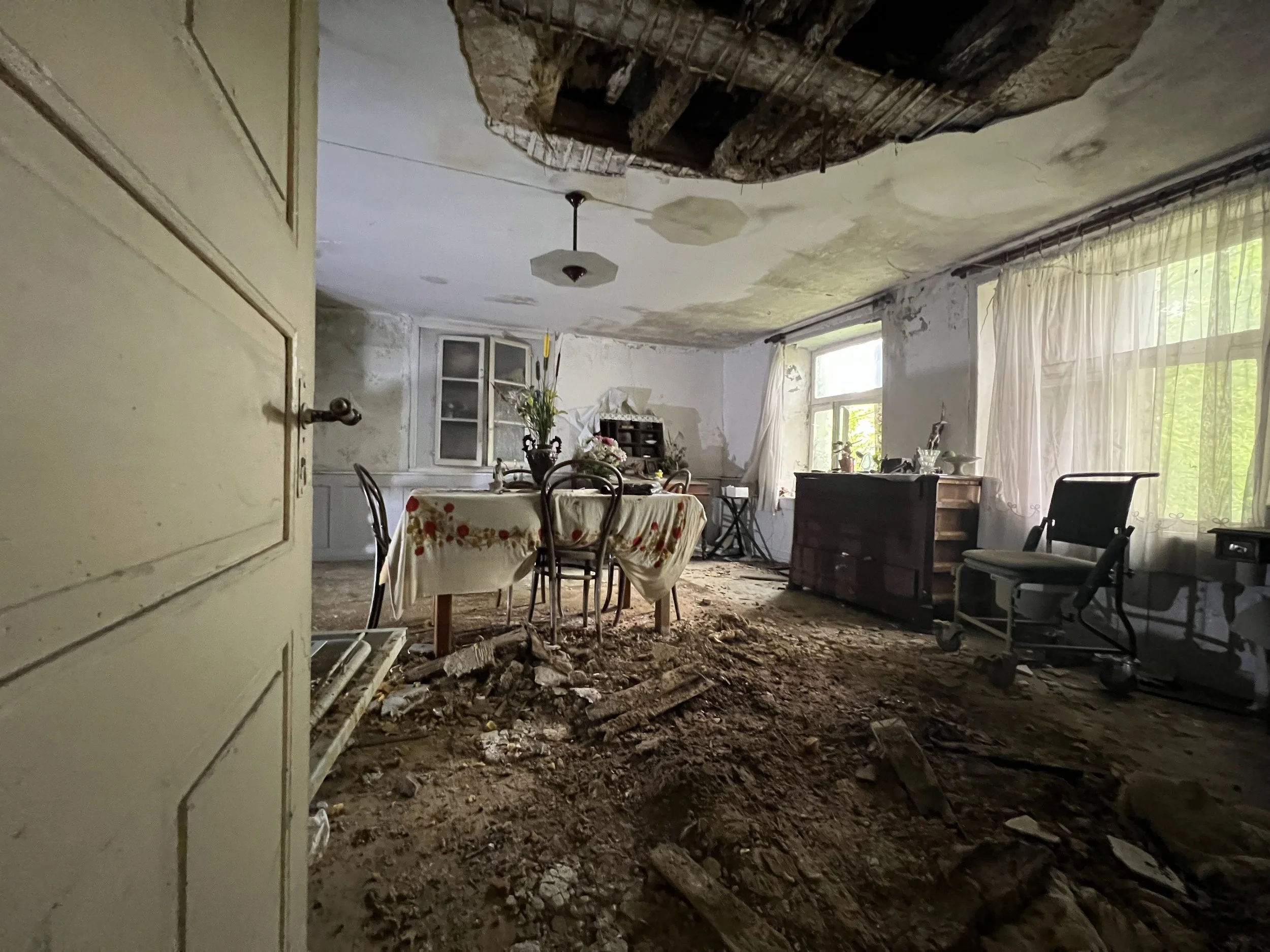 Intérieur d’une maison abandonnée avec plafond endommagé et débris