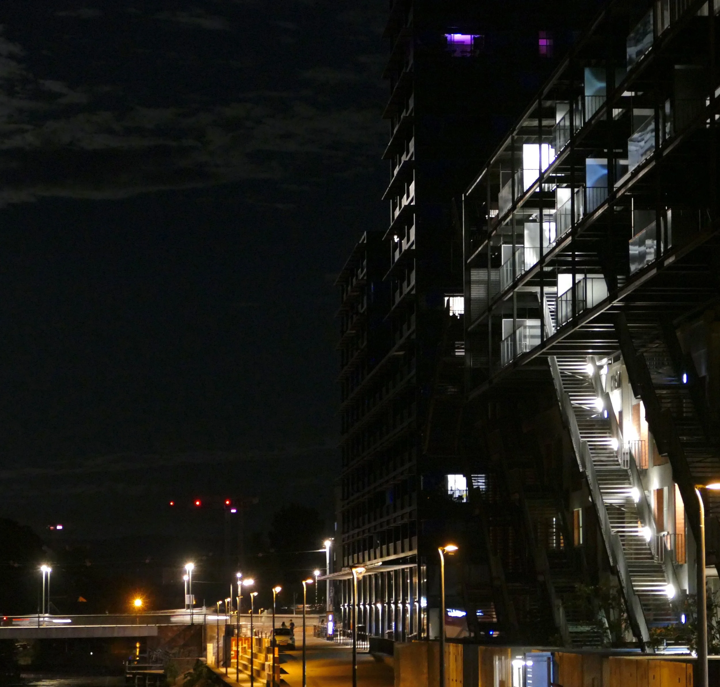 Photographie de Strasbourg la nuit montrant un immeuble contemporain éclairé, avec ses fenêtres illuminées.