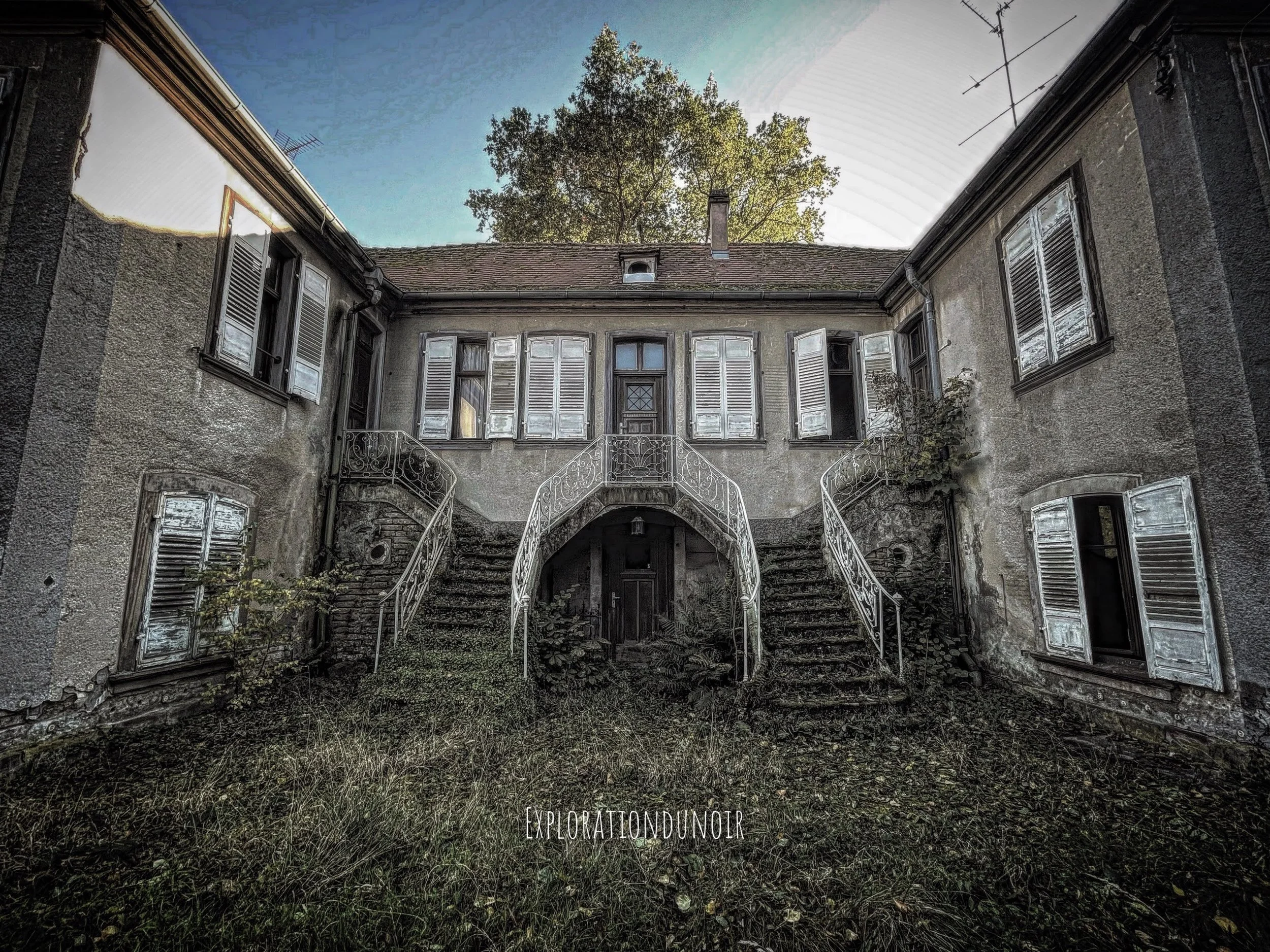 Maison ancienne en pierre entourée de végétation