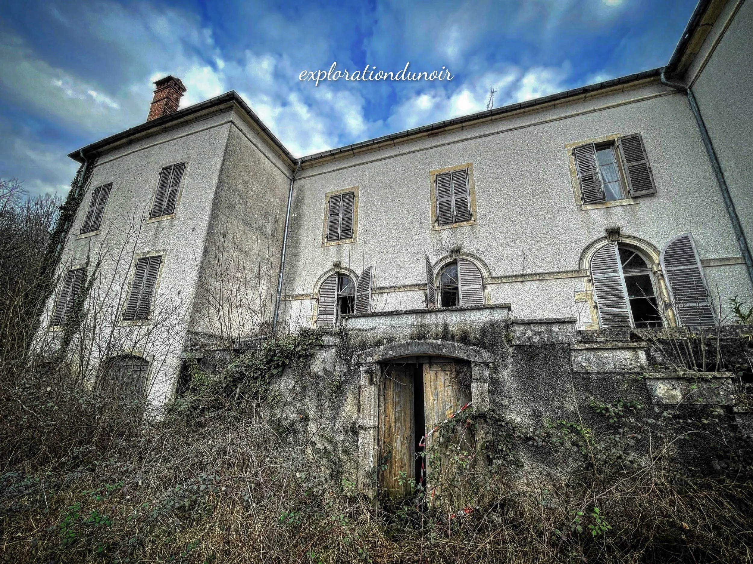 Façade d’une ancienne bâtisse abandonnée sous un ciel bleu