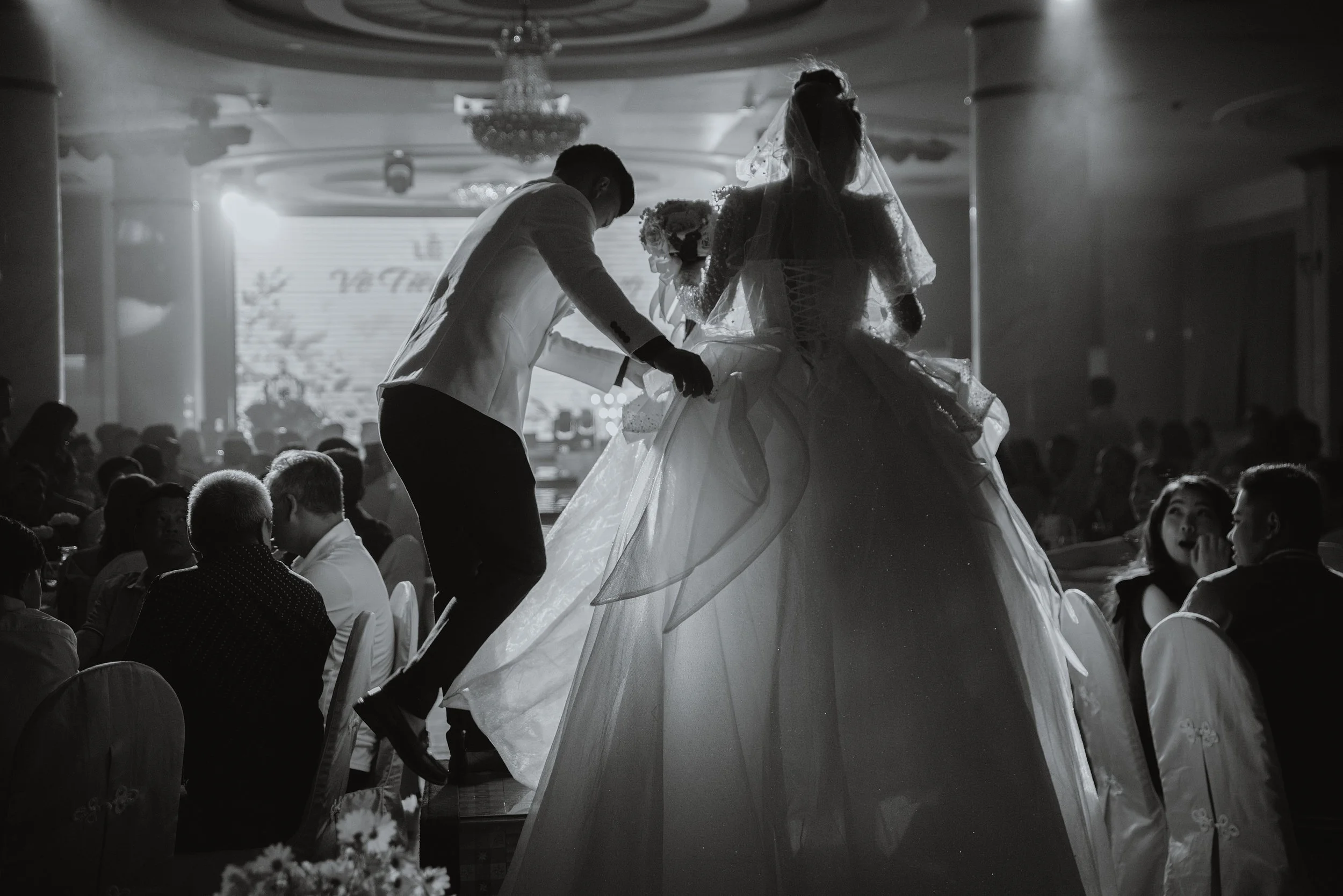 Photographie de mariage en noir et blanc, couple dansant lors d’une réception en Alsace.