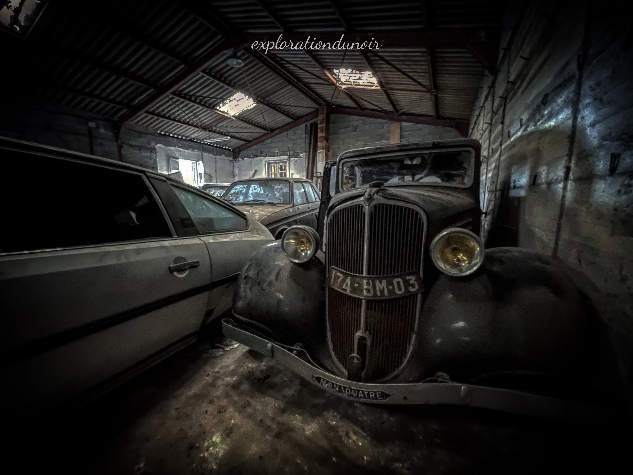Ancienne grange abandonnée avec plusieurs voitures anciennes