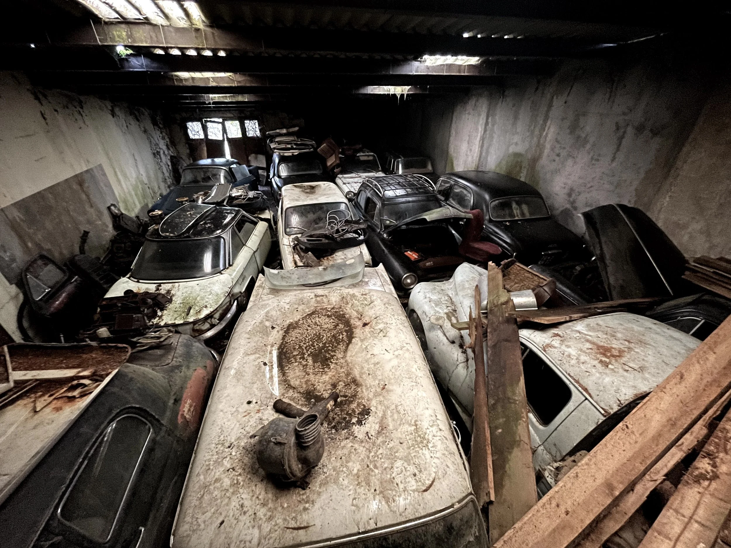 Garage abandonné rempli de voitures anciennes rouillées