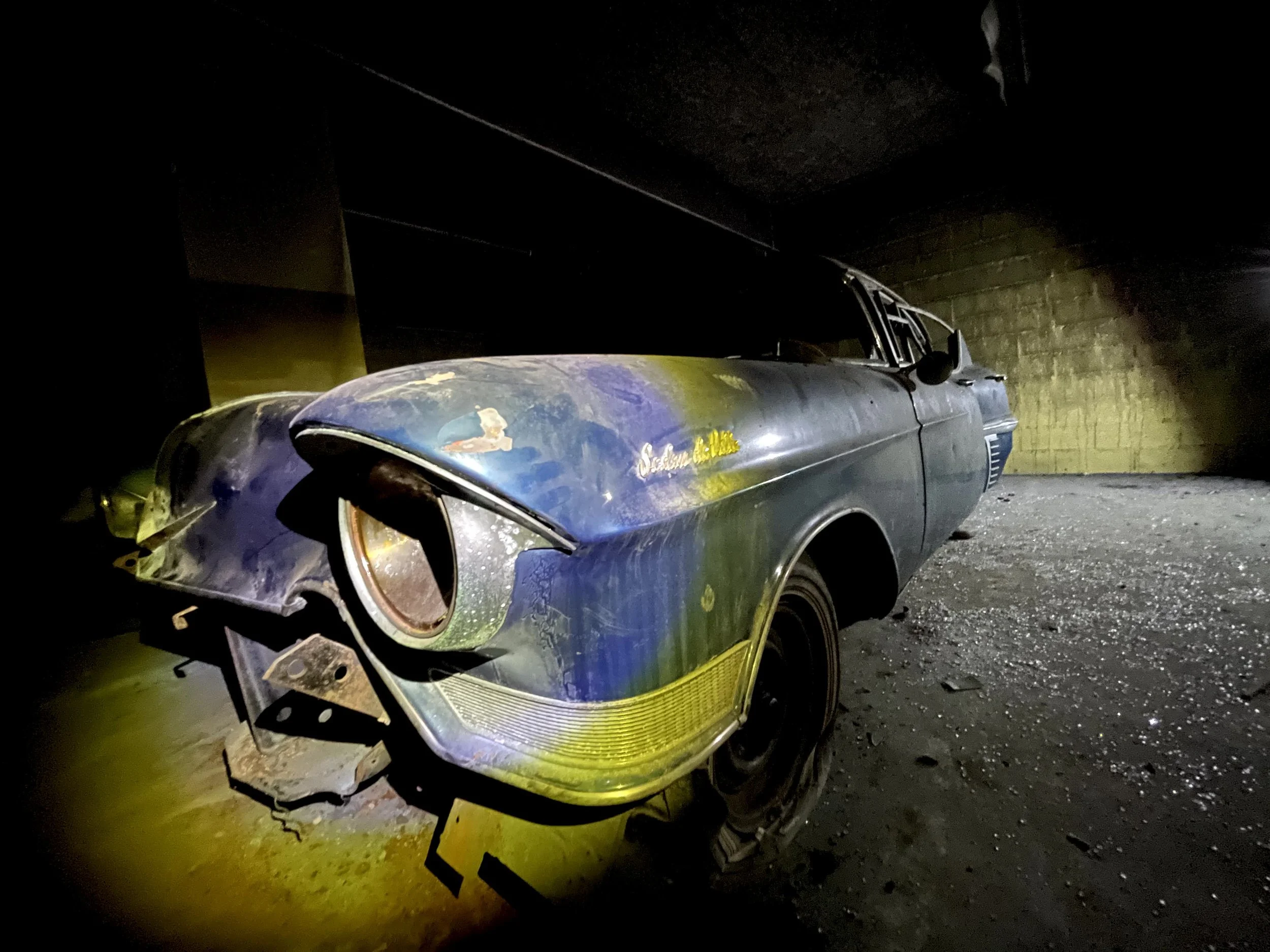 Voiture ancienne cadiac abandonnée dans un bâtiment sombre