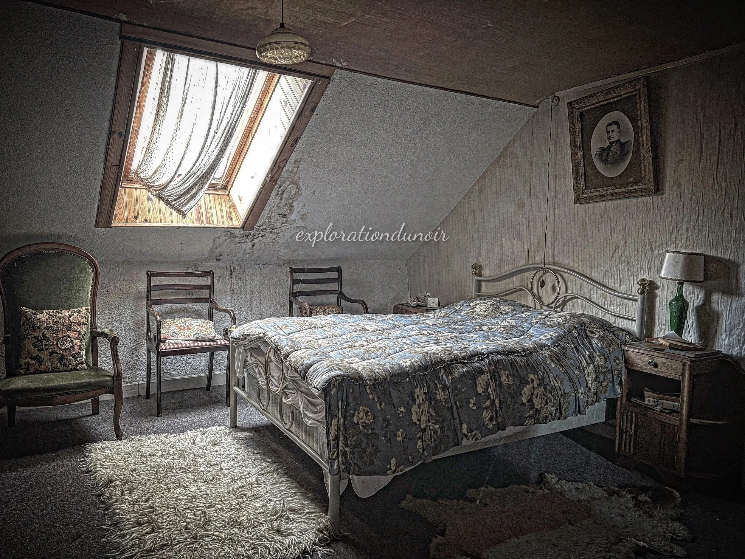 Chambre ancienne avec lit, mobilier en bois et plafond mansardé