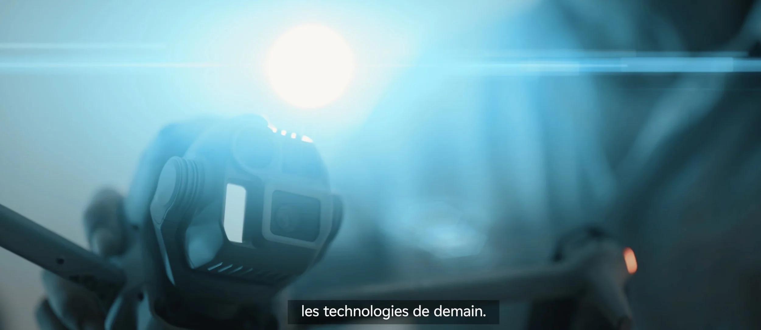 Une personne tenant une tablette ou un dispositif numérique, avec la lumière du soleil en arrière-plan et des effets de lens flare.