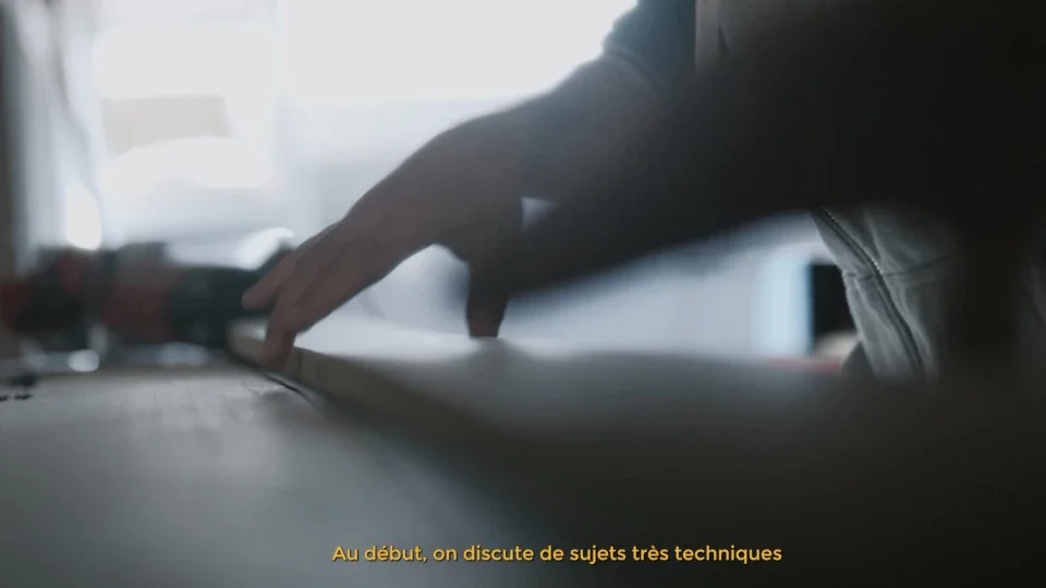 Une main d'une personne qui travaille sur un clavier d'ordinateur, avec un fond flou et une lumière naturelle.