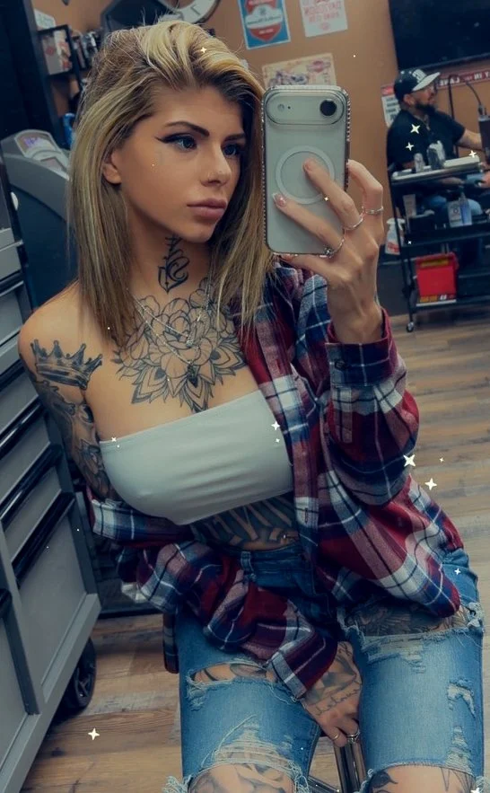 Lala taking a mirror selfie in a plaid shirt