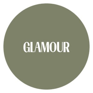A circular logo with a muted green background and the word 'GLAMOUR' in white capital letters