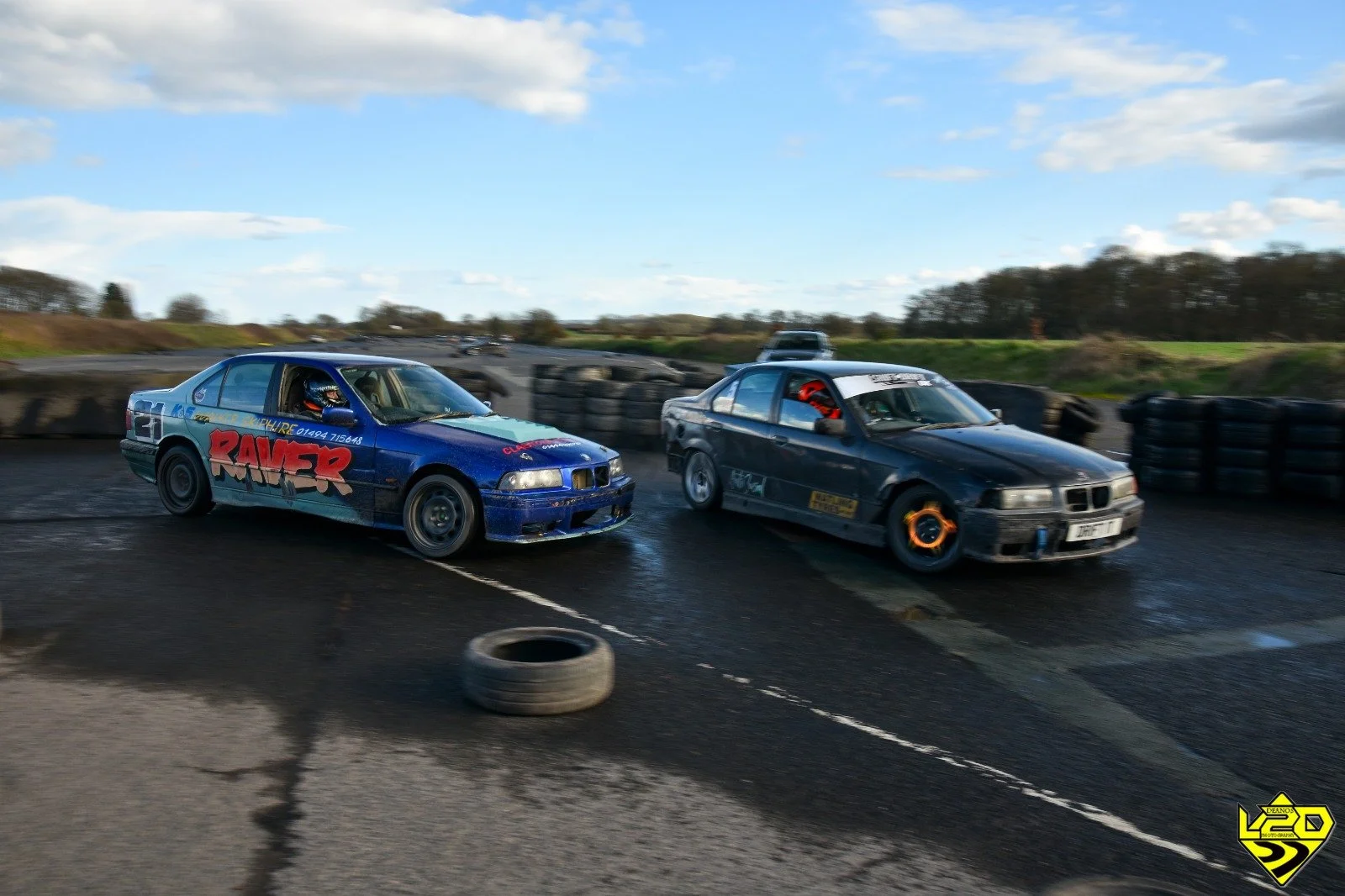 Two drift cars sliding next to each other during a drift event