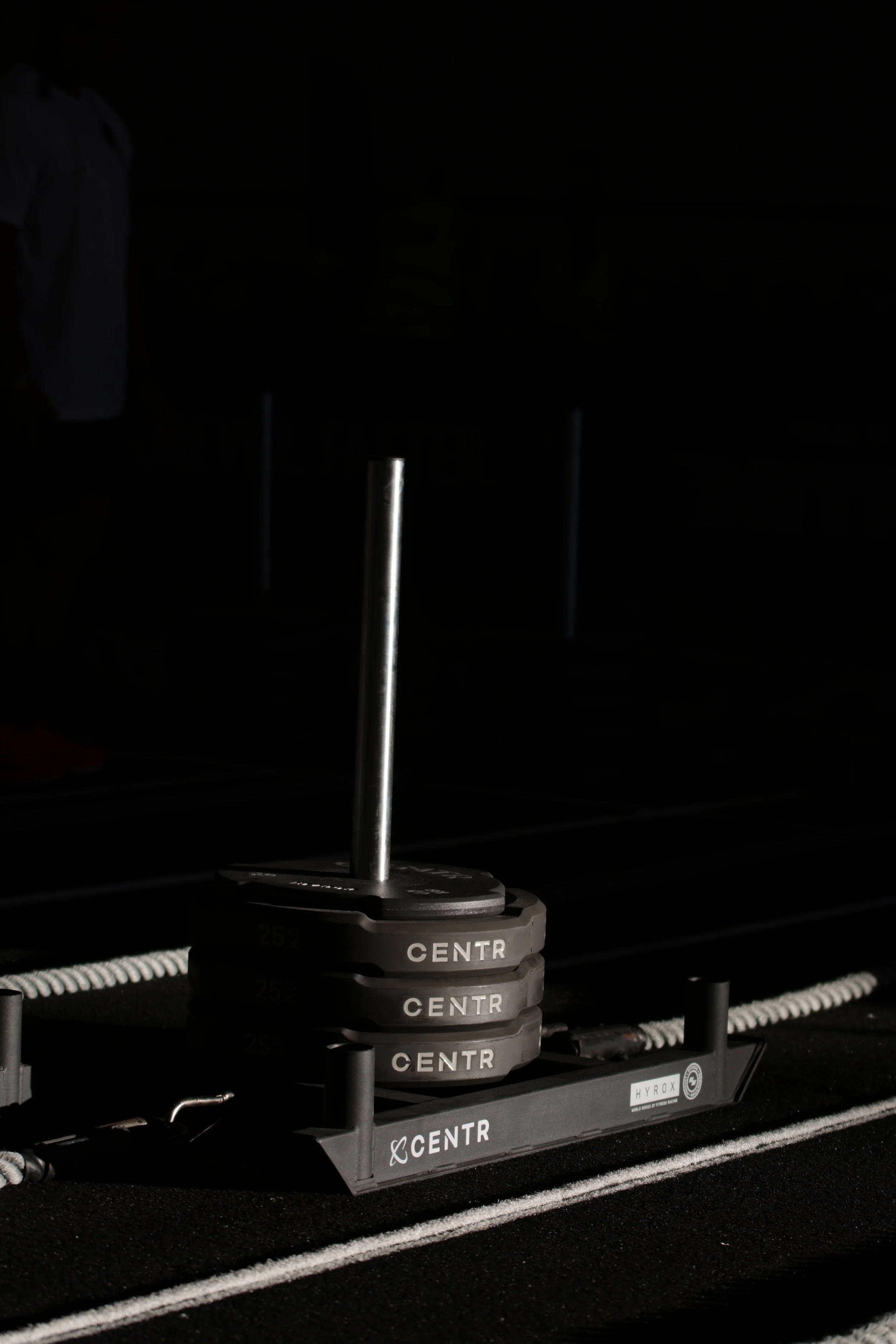 Close-up of a black radio-controlled drone with a vertical antenna, labeled 'CENTR,' on a dark surface with white marking lines.