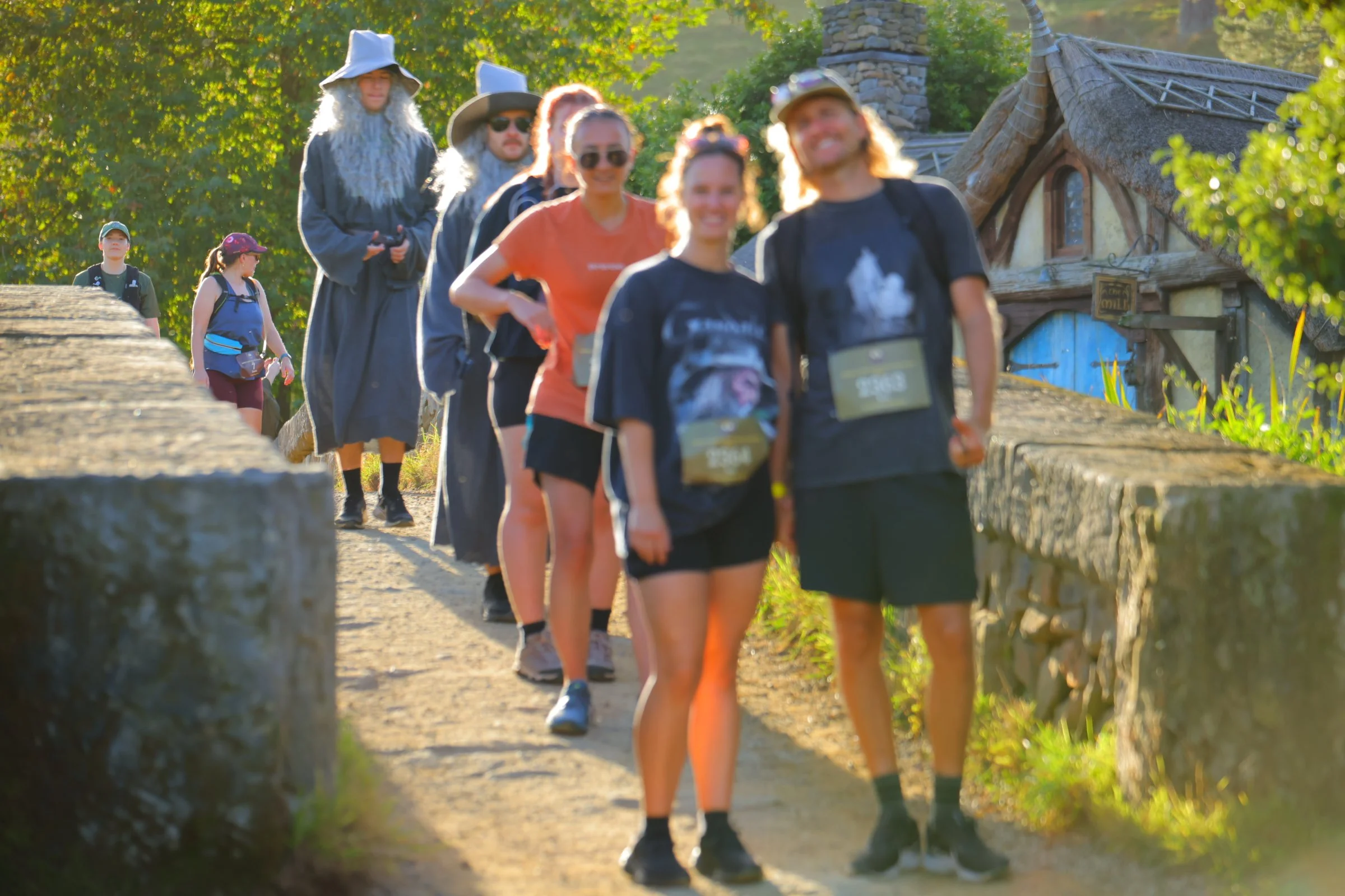 Group of people dressed as wizards and casually walking on a stone path outdoors during daytime.