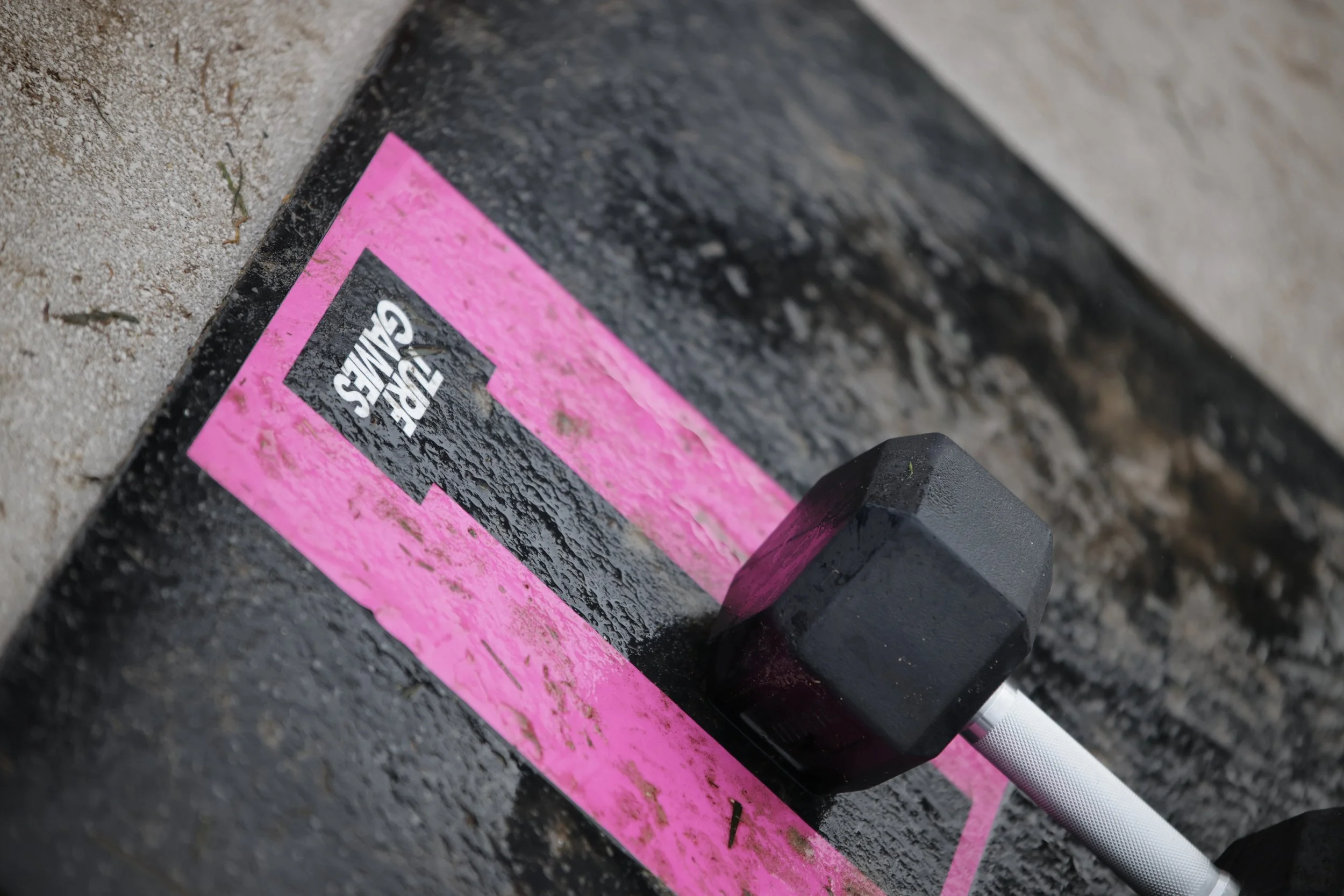 Close-up of a black marker laying on a pink and black chalkboard surface, with part of a pink sticker that reads 'GET GAVE' visible.