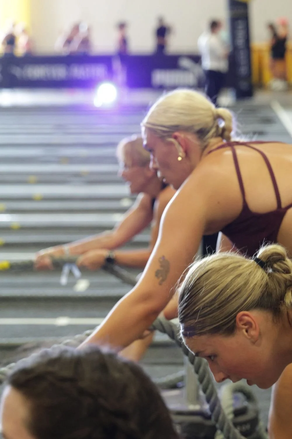 Women participating in a fitness class or workout session, doing stretching exercises on gym mats.