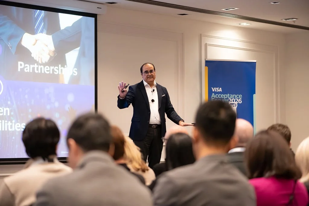 Business speaker giving a presentation at a conference, with a slide about partnerships and opportunities, and an audience listening attentively.
