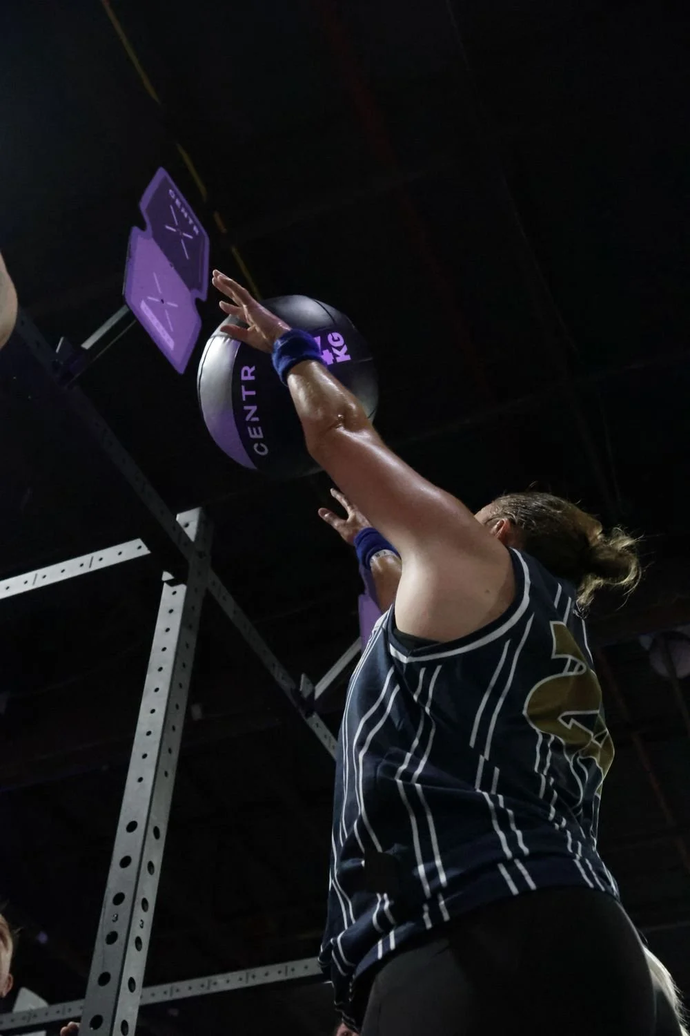Person performing a workout on a medicine ball with labeled text 'CENTER' and 'KG' in a gym setting.