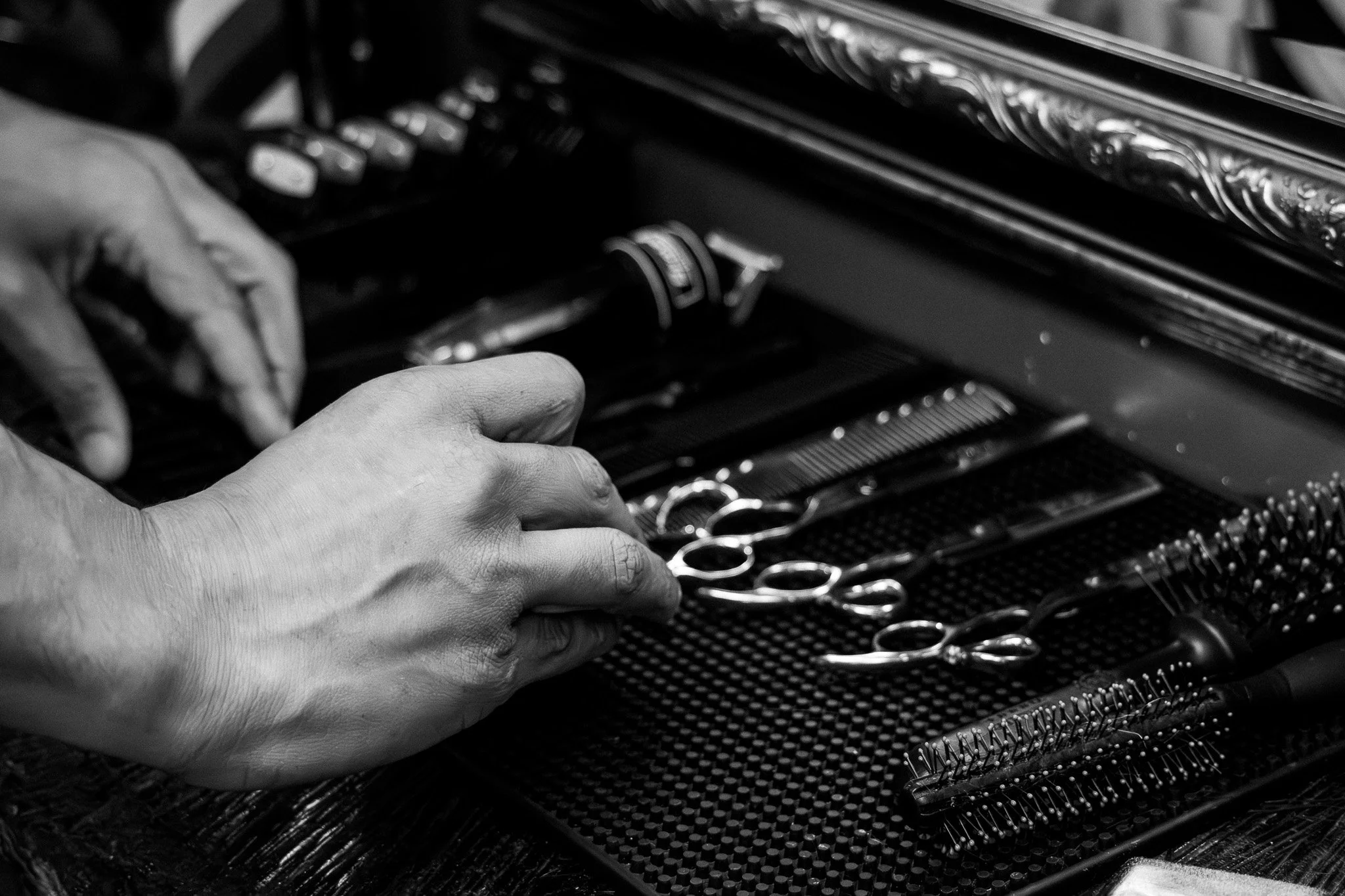 Close-up of a hand opening a drawer of a jewelry box, revealing various silver jewelry pieces including rings and bracelets.