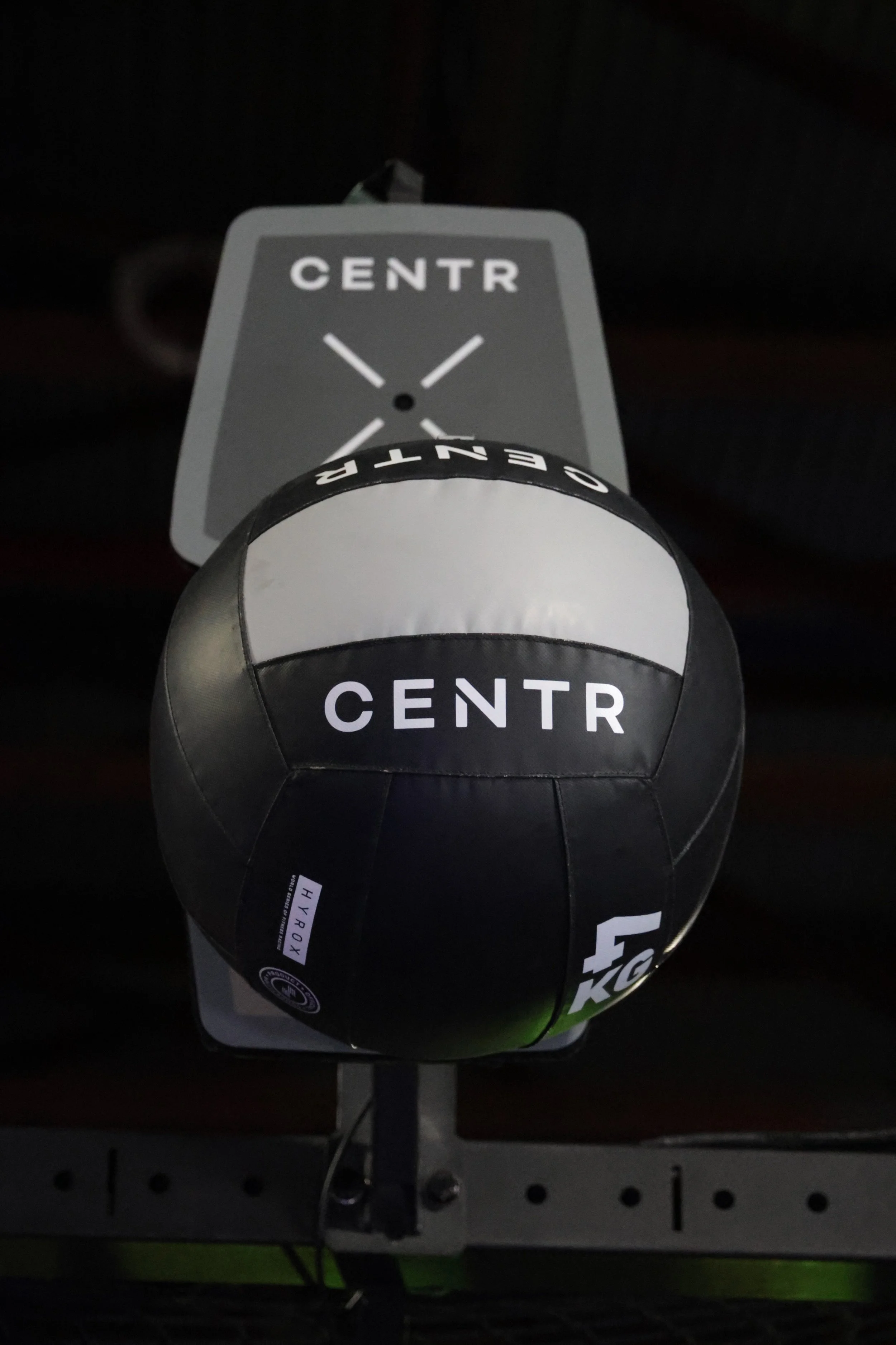 A motion-activated camera capturing an autographed soccer ball on display, with a tag indicating 'HYROX' and a display stand.