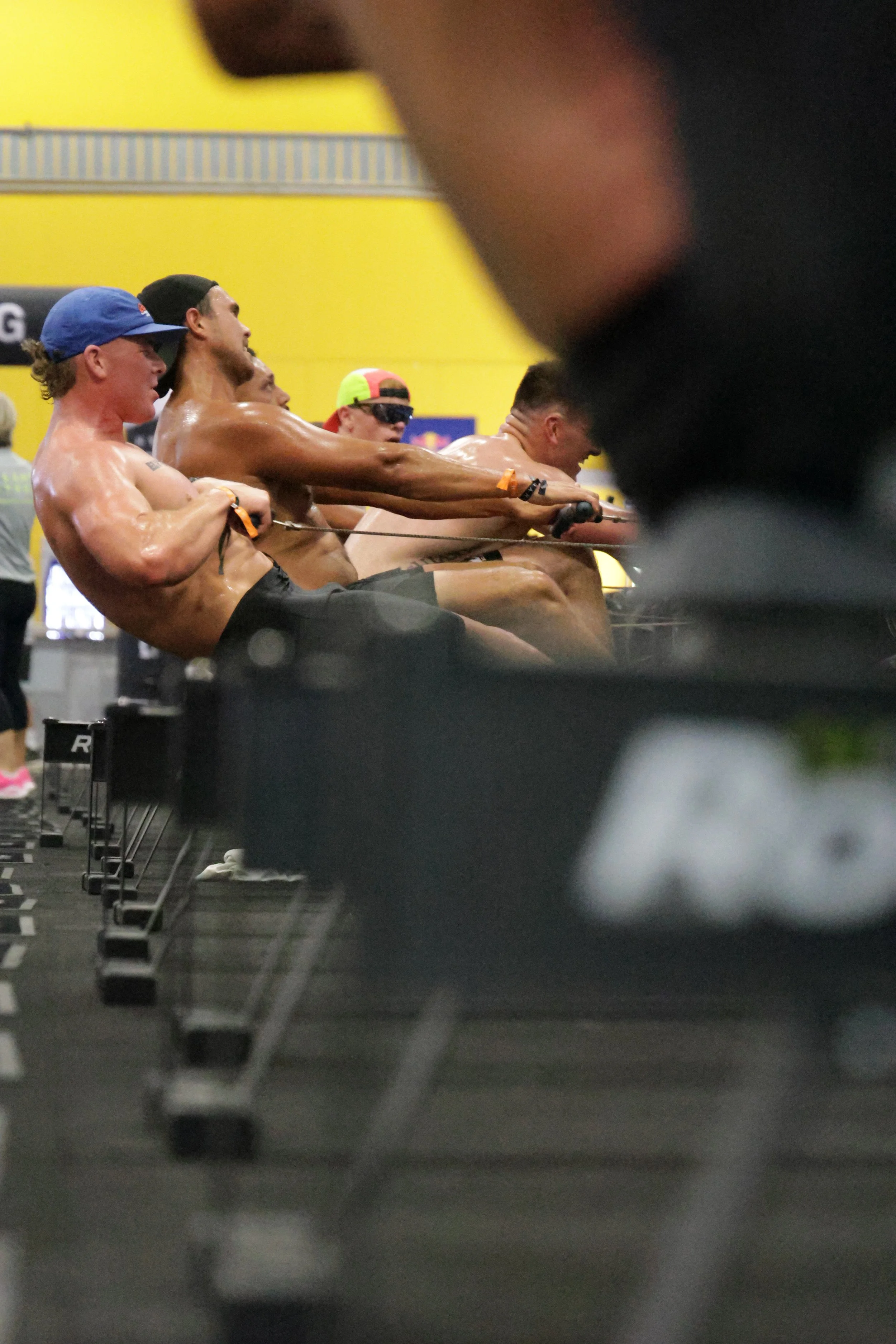 Athletes participating in a rowing competition at an indoor sports facility.