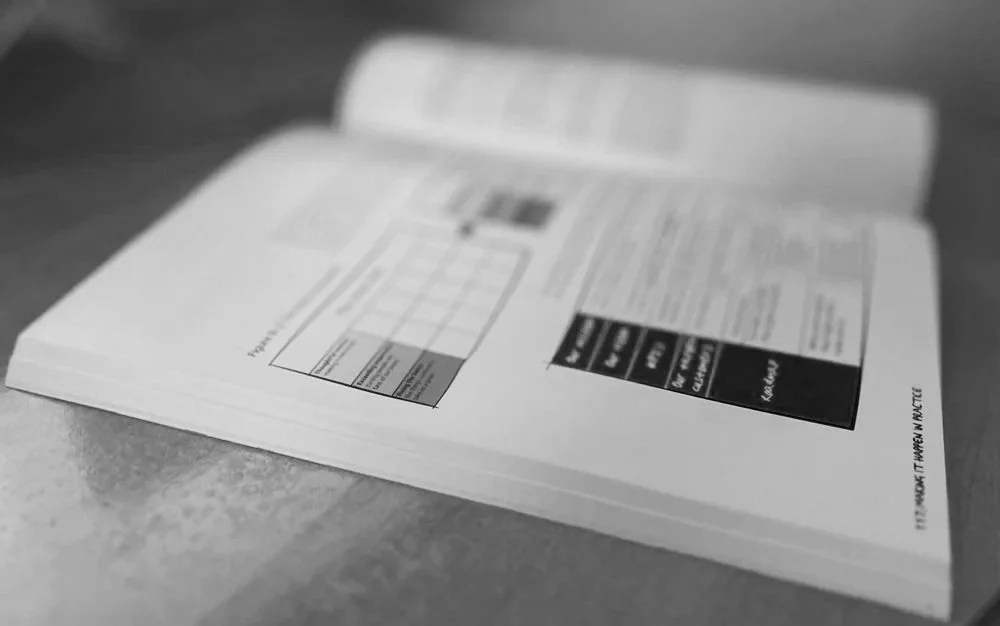 Open book or magazine displaying a table or chart with text and images, on a flat surface.