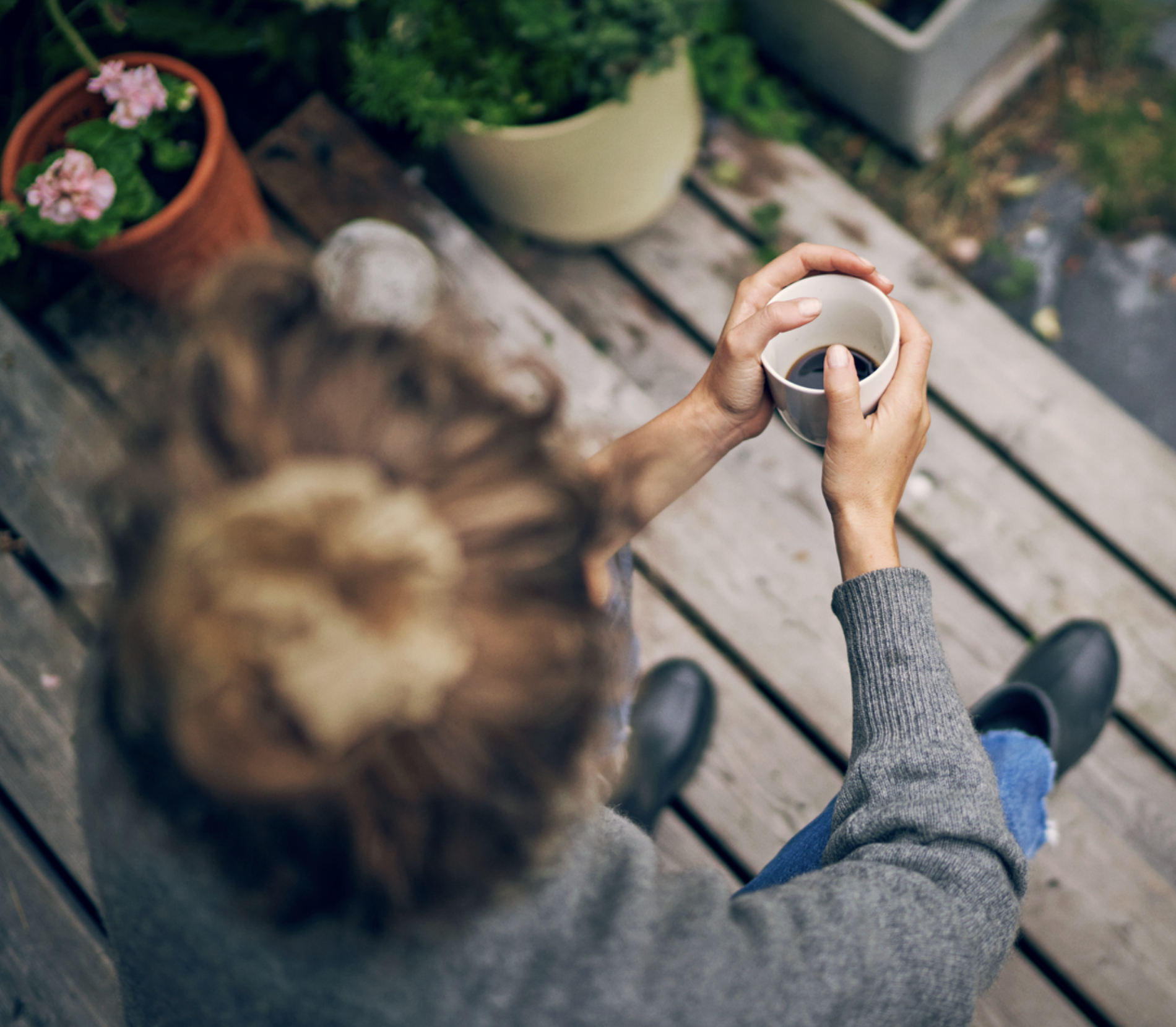 Woman holding a white coffee mug with dark coffee. Brand photography for hardware store chain.