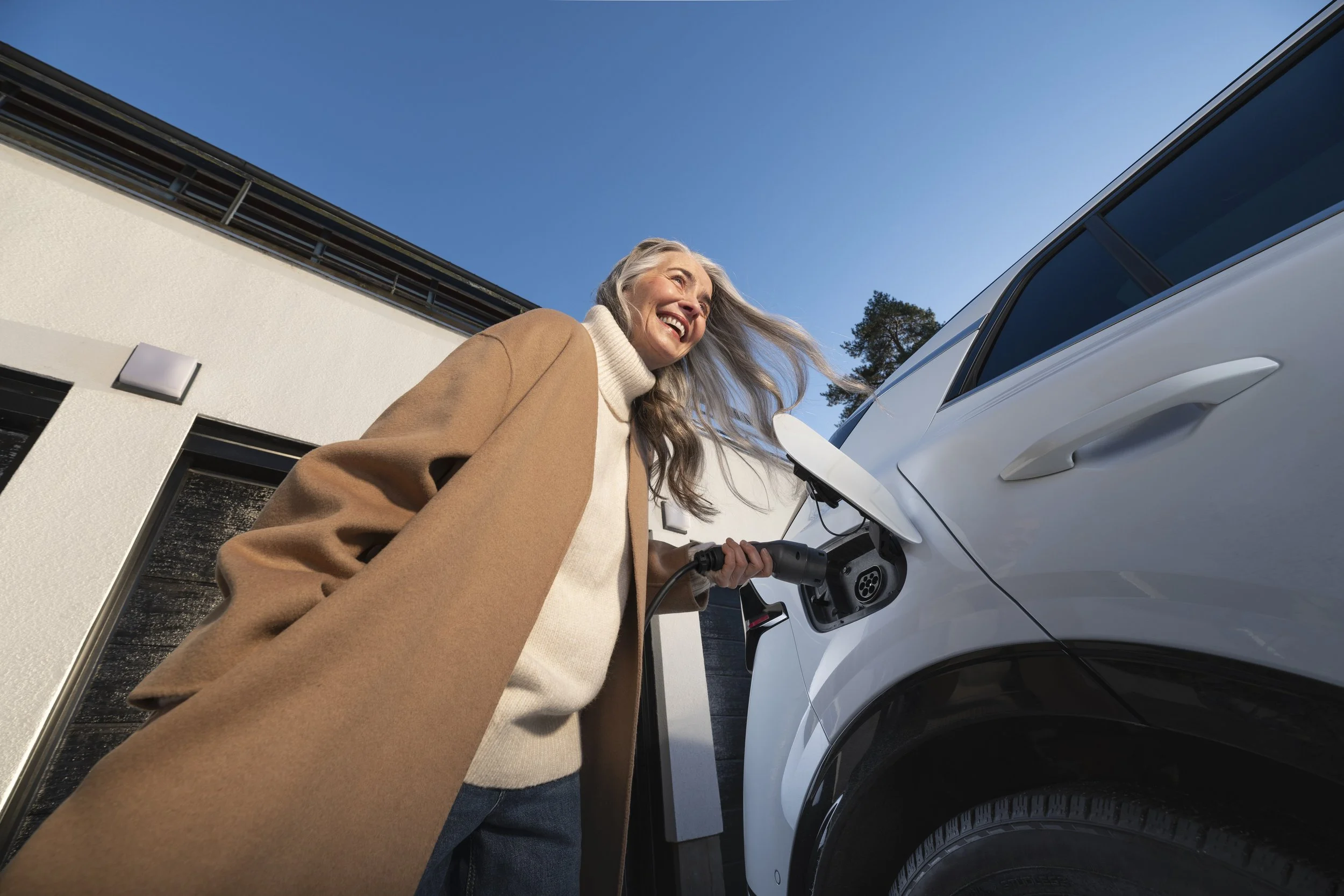 woman charging her car in sun shine. brand photography