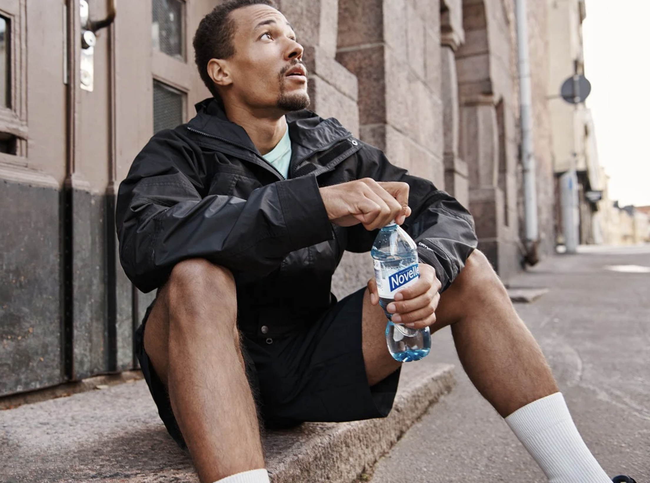 man holding a water bottle after a run. brand photo for hartwall