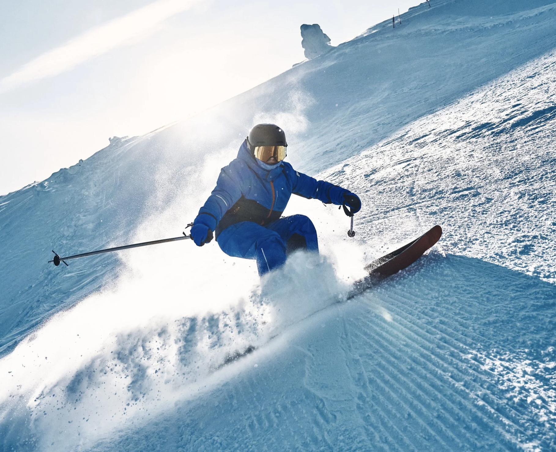 A child skiing down a snow-covered slope on a bright, sunny day. Ad photo for Reima.