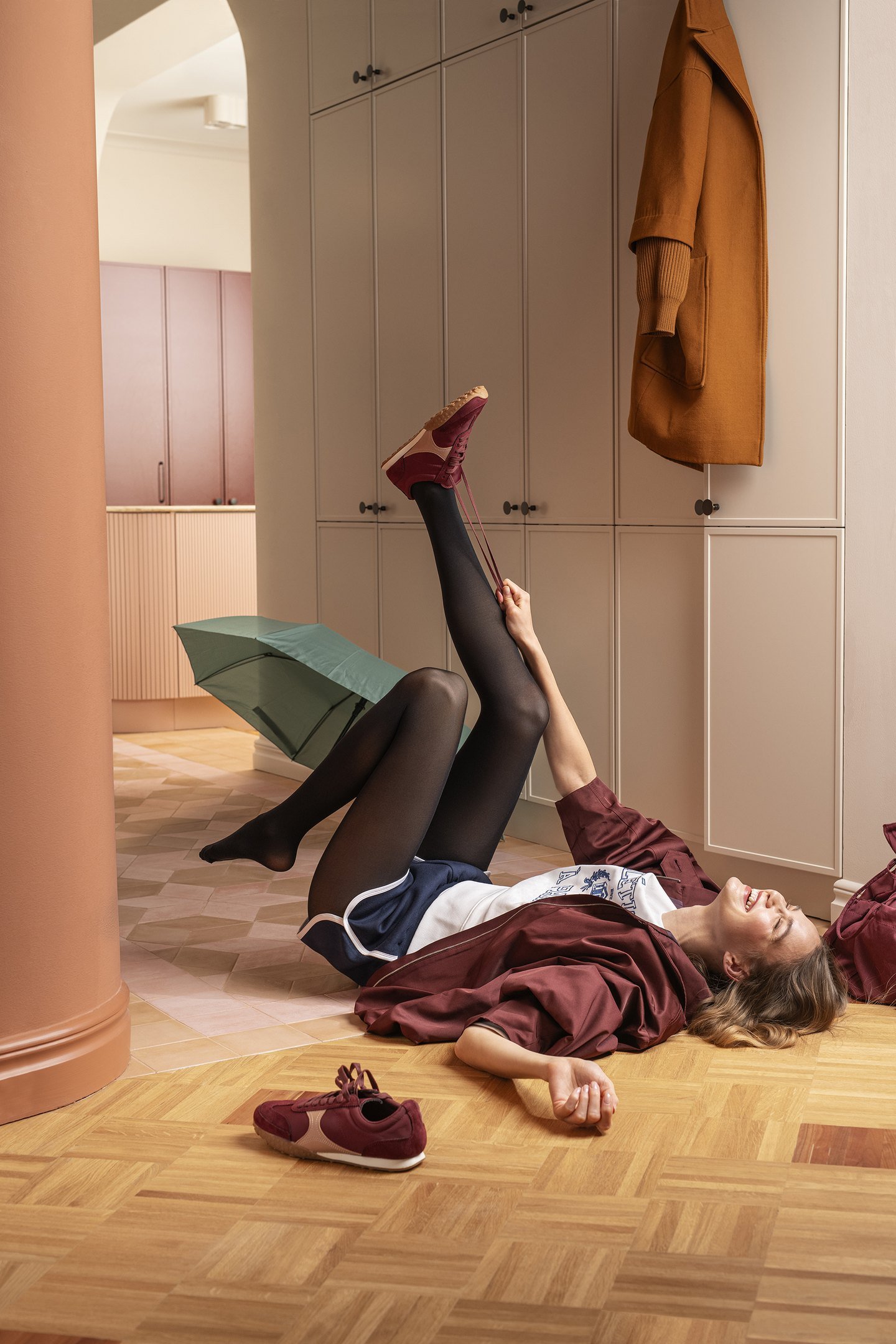 A woman getting dressed on the floor. Ad photo for Norlyn.