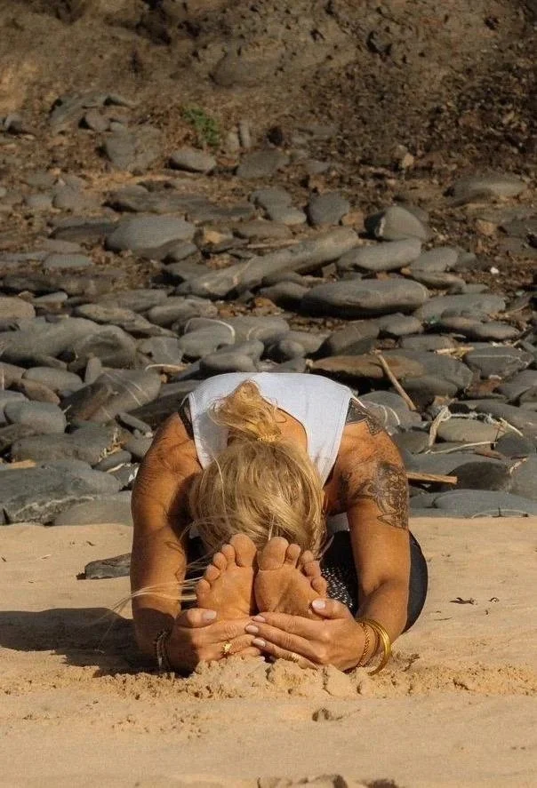 Kaja in der Vorwärtsbeuge Paschimottanasana am Strand