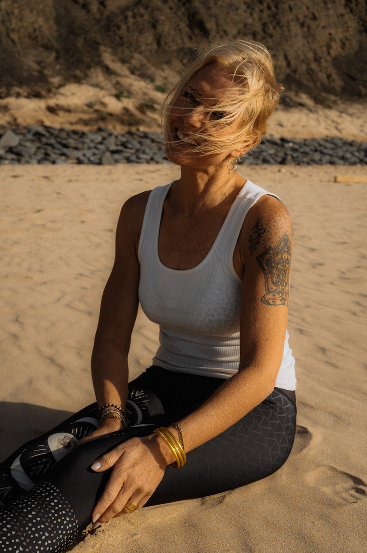 Kaja Dass Pavan sitzt am Strand; der Wind bewegt ihr Haar.