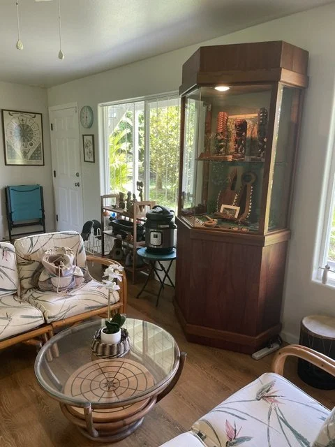 Wohnzimmer von Serge Kahili King auf Hawaii mit Vitrine und Rattanmöbeln