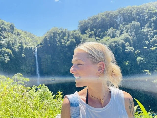 Kaja vor einem Wasserfall auf Hawaii, im Bild ein heller Lichtschimmer