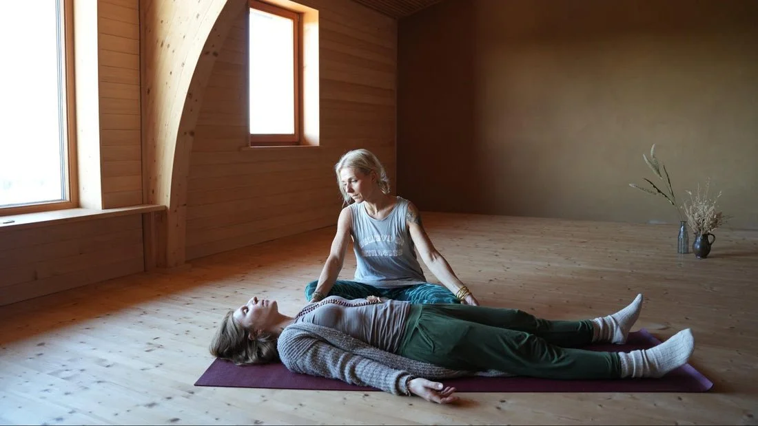 Kaja begleitet eine Breathwork-Session im lichtdurchfluteten Raum.