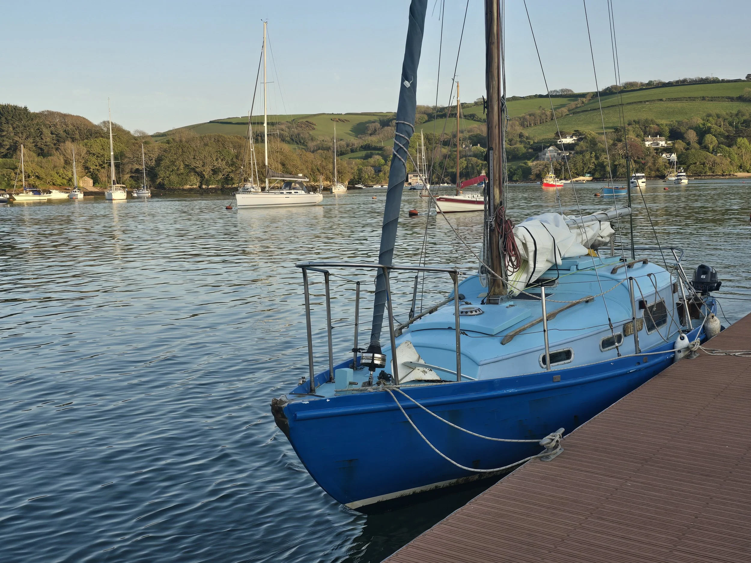 A small sailboat for charter. Berthed alongside  an anchorage ready for charter and overnight stays