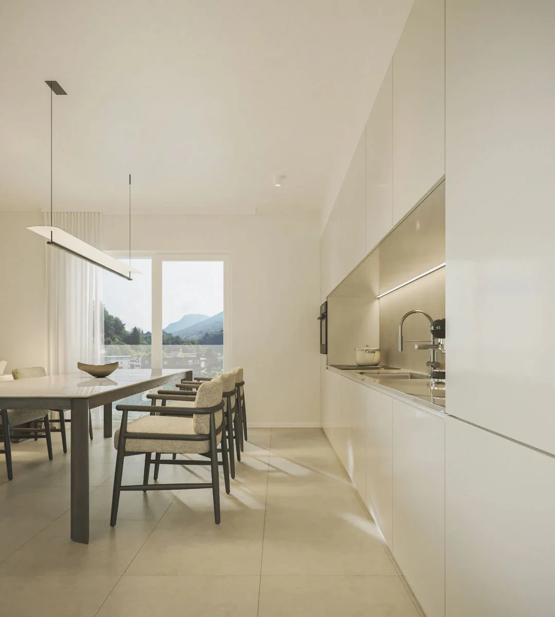 Interno moderno di una cucina e sala da pranzo con grandi finestre che mostrano montagne in lontananza, arredi beige e bianco.