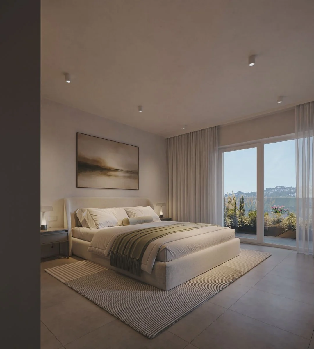 Una camera da letto moderna con letto matrimoniale, mediante tende trasparenti si vede un balcone con vista su un paesaggio verde e colline al tramonto.