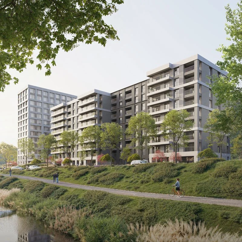 Immobile moderno residenziale con molteplici piani, balconi e grandi finestre, circondato da alberi e un parco con un sentiero e un lago, giorno soleggiato.