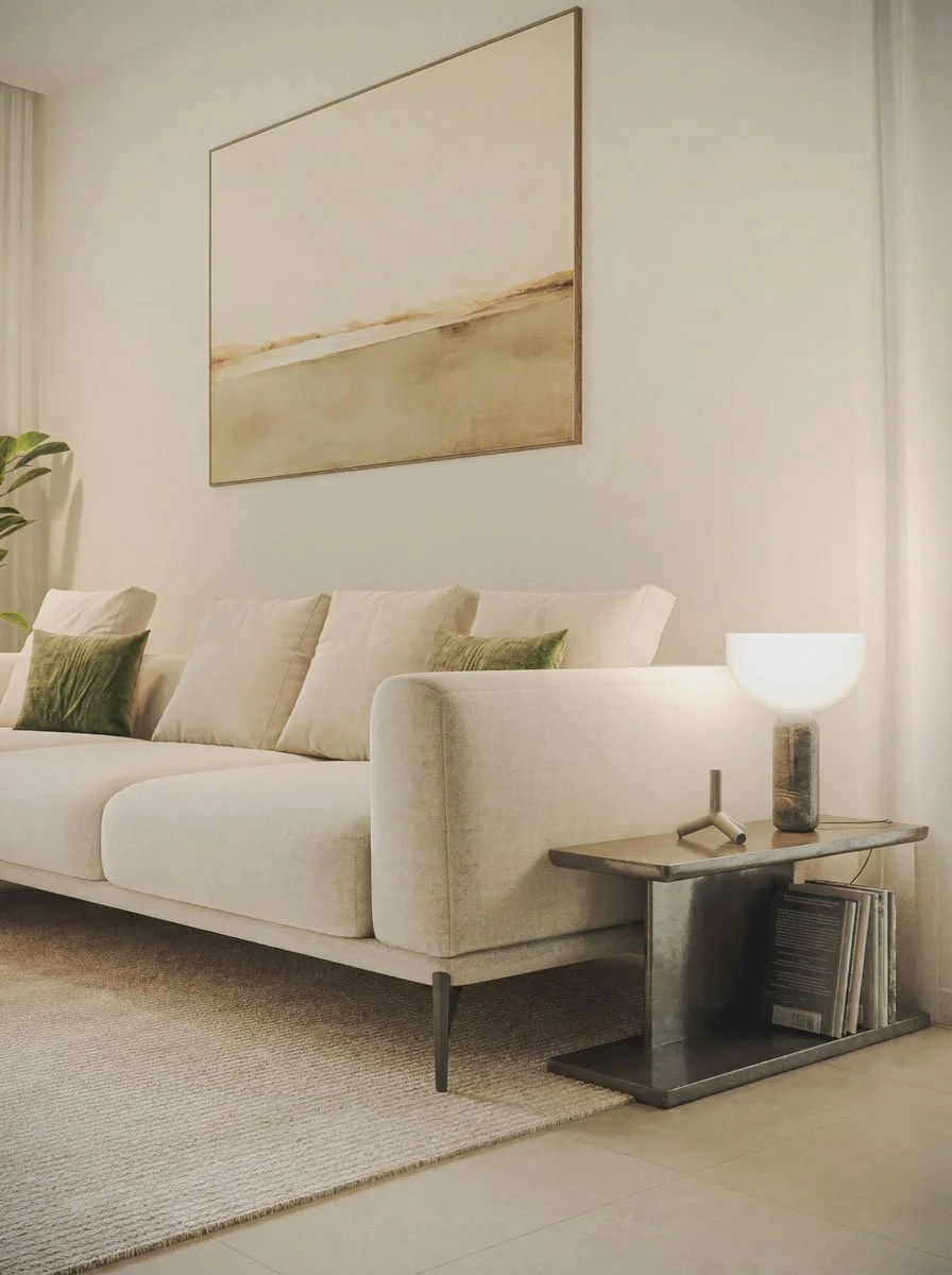 Soggiorno con divano beige, ripiano con lampada e libri, dipinto astratto sopra il divano, piante verdi accanto.