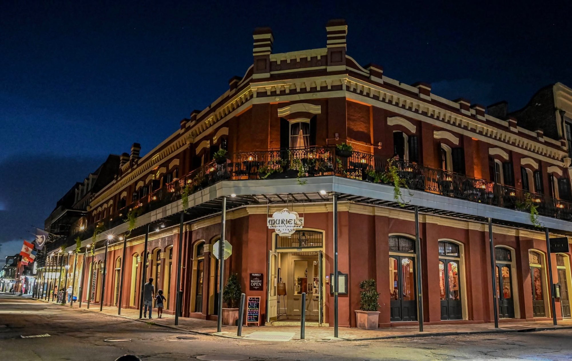 Muriel's Jackson Square building illuminated at night on the corner of Chartres and St. Ann streets