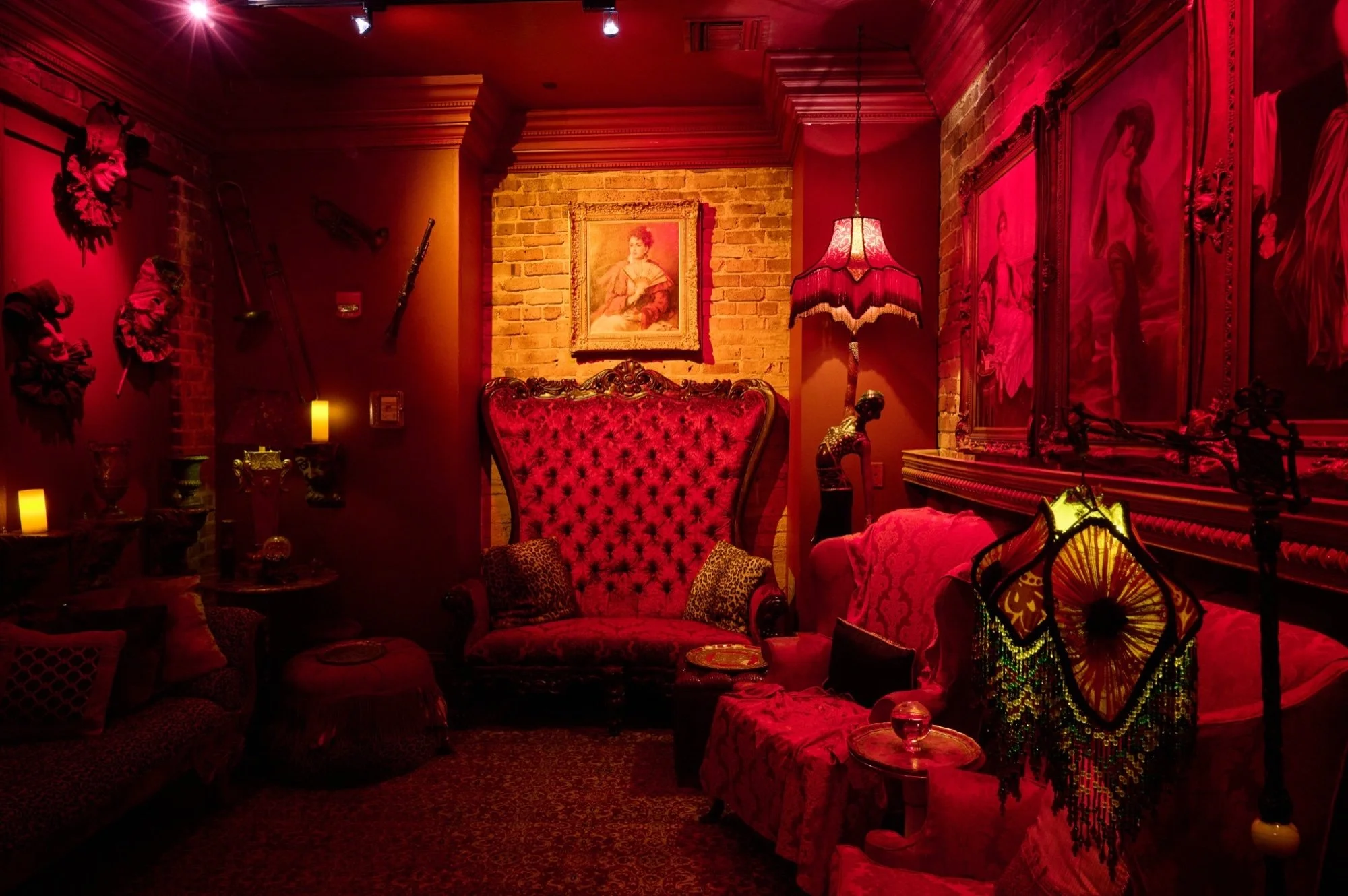 A richly furnished room in Muriel's Séance Lounge illuminated with deep red light