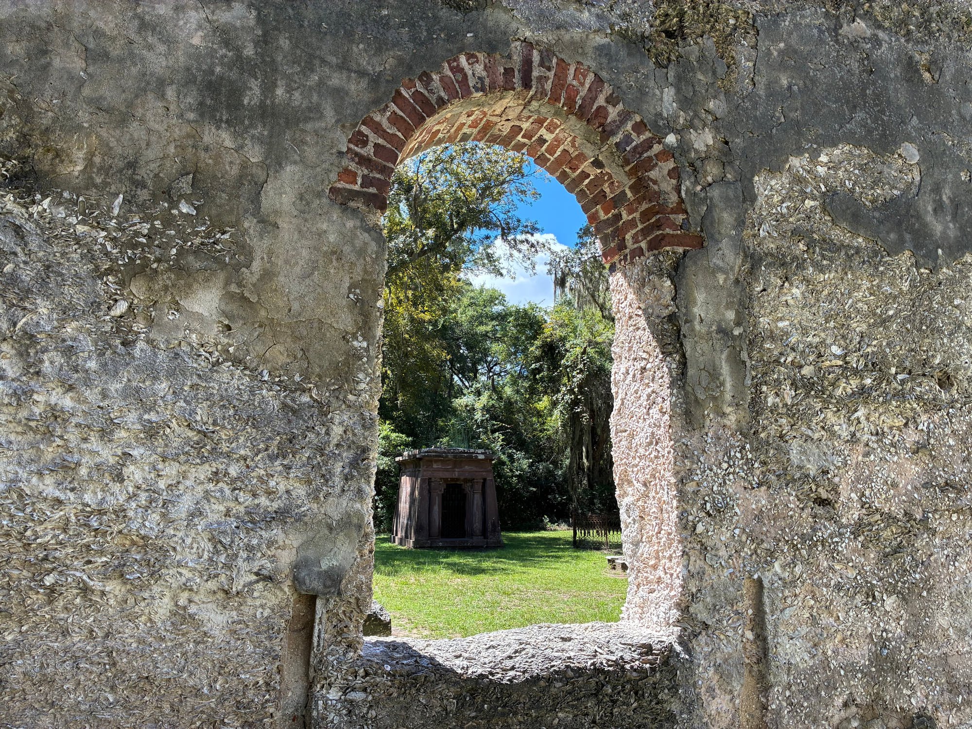 Detail of the Chapel of Ease ruins framed through a brick arch