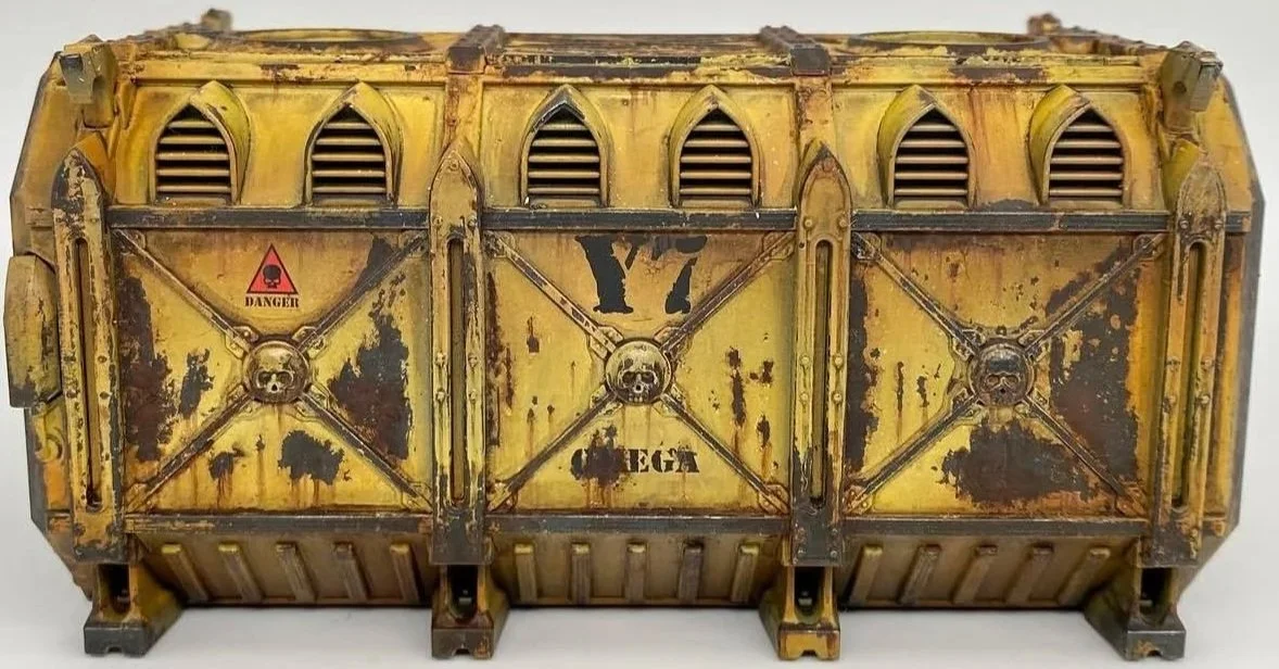 A rusted, yellow, industrial-style container with warning and skull symbols, vent openings, and the number 17 branding.